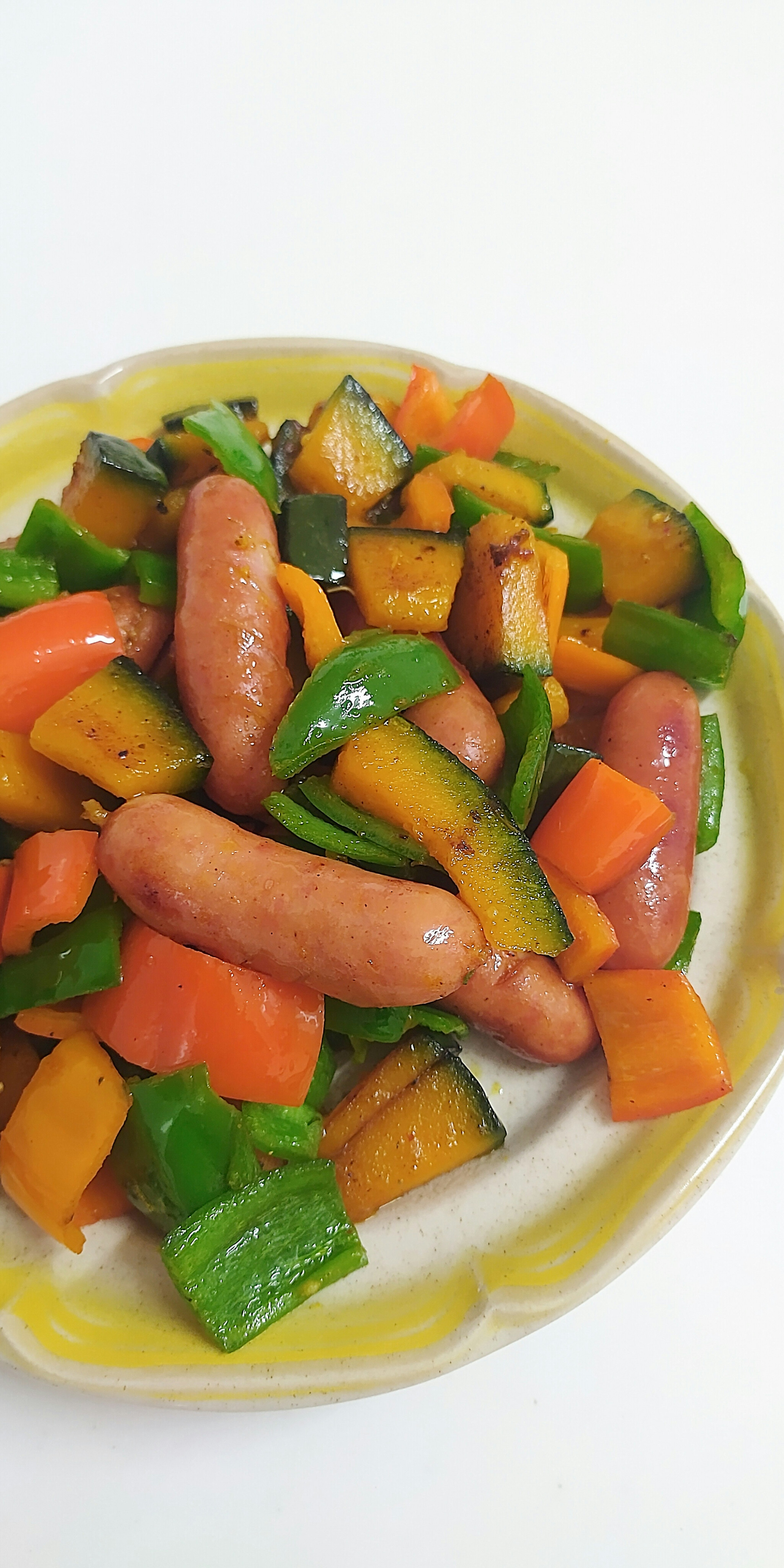 Verduras coloridas salteadas con salchichas servidas en un plato