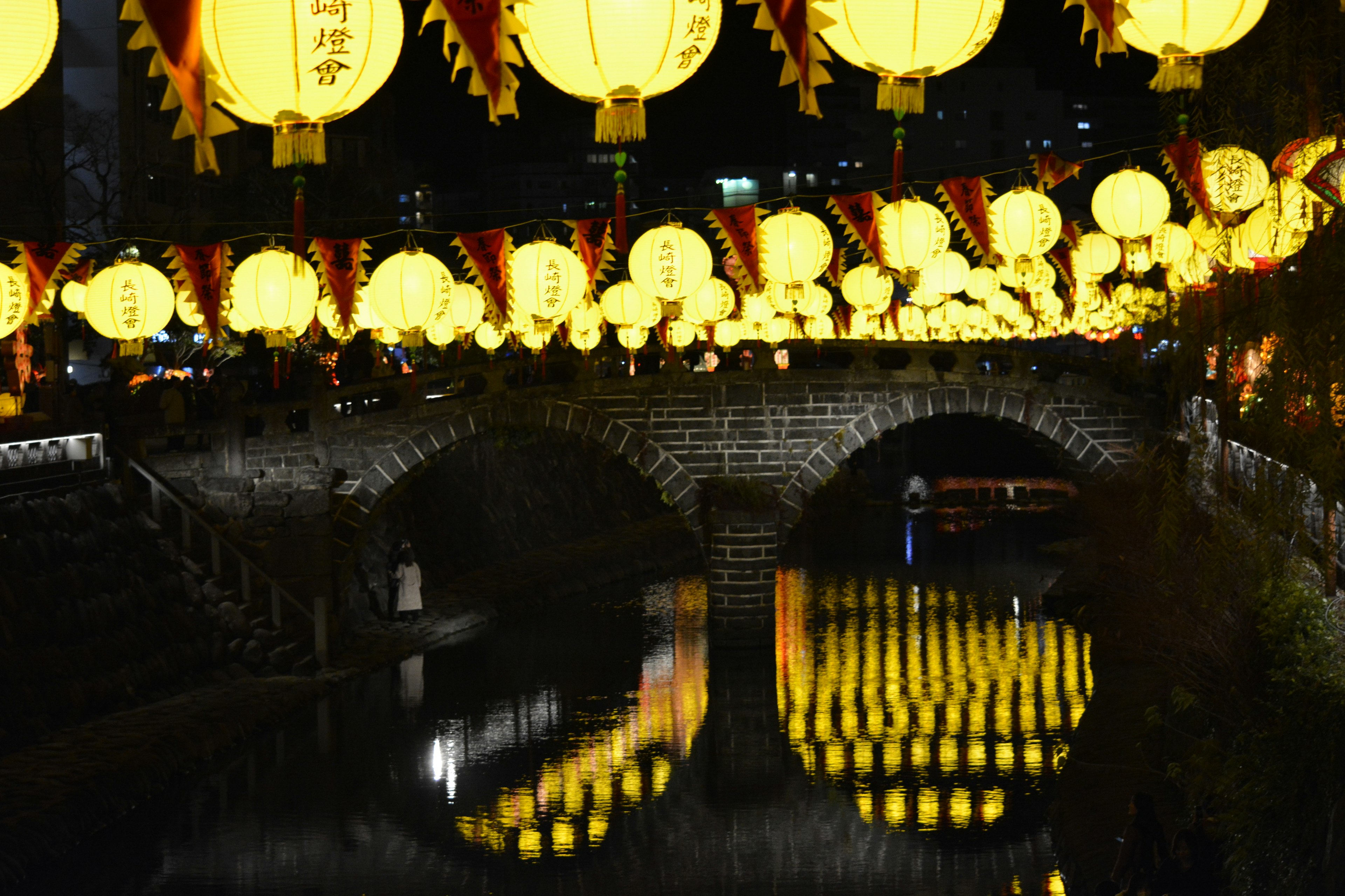 夜晚河面上反射着黄灯笼的桥的美丽景观