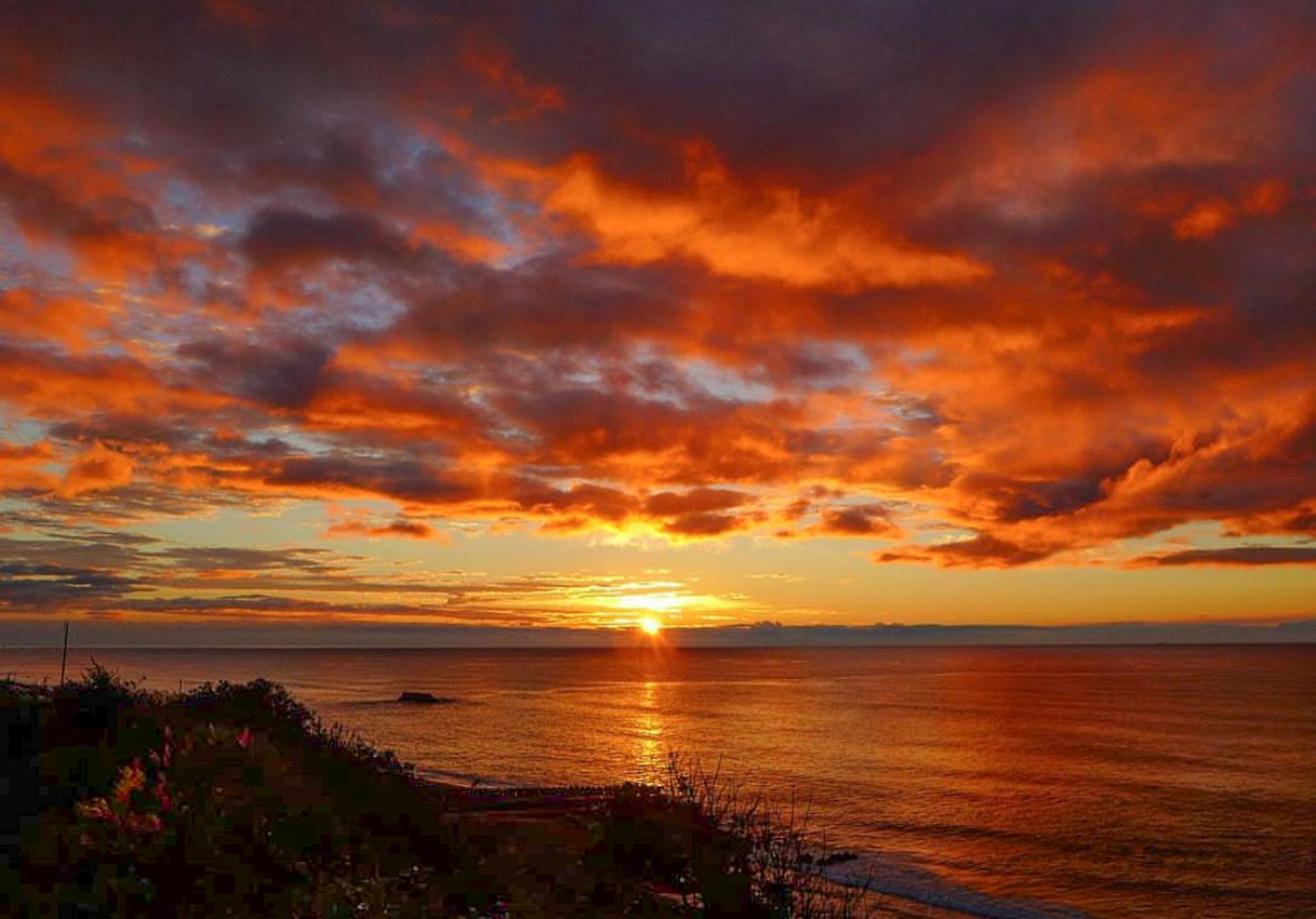 美しい夕日が海に沈む景色 赤い雲とオレンジ色の空