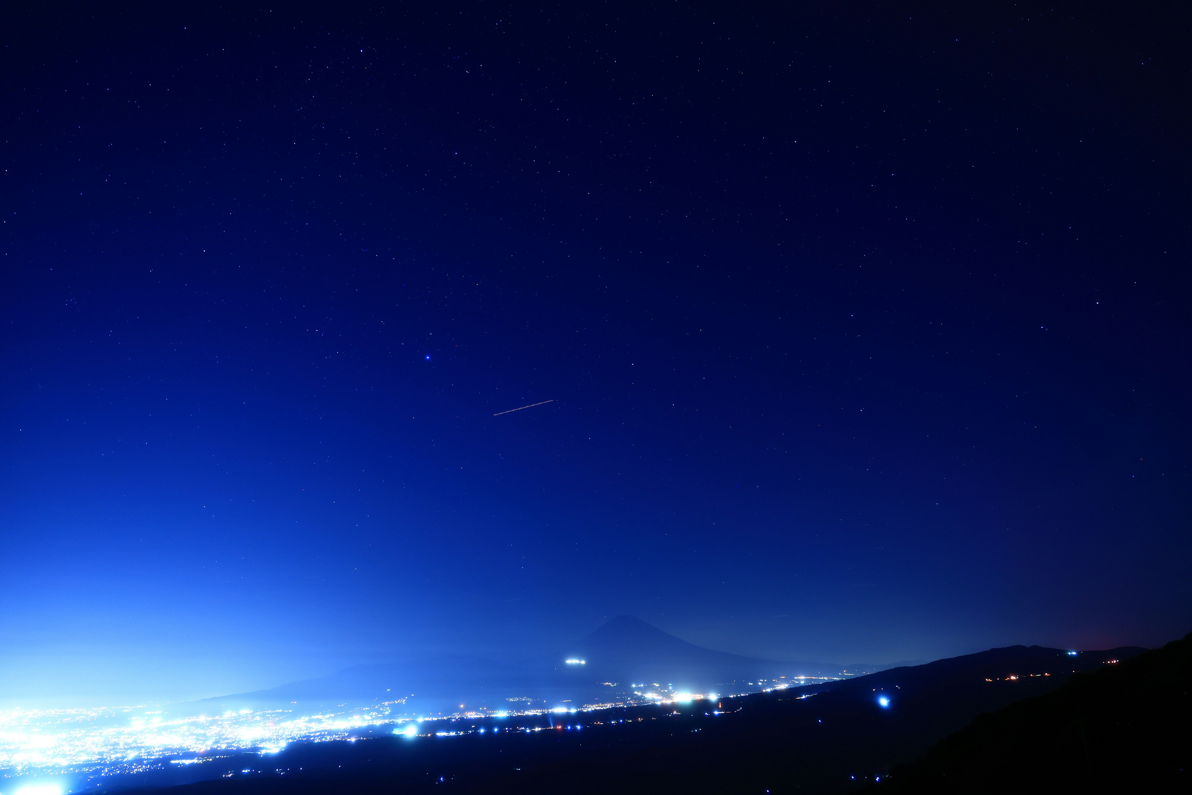 Night sky filled with stars and a serene cityscape