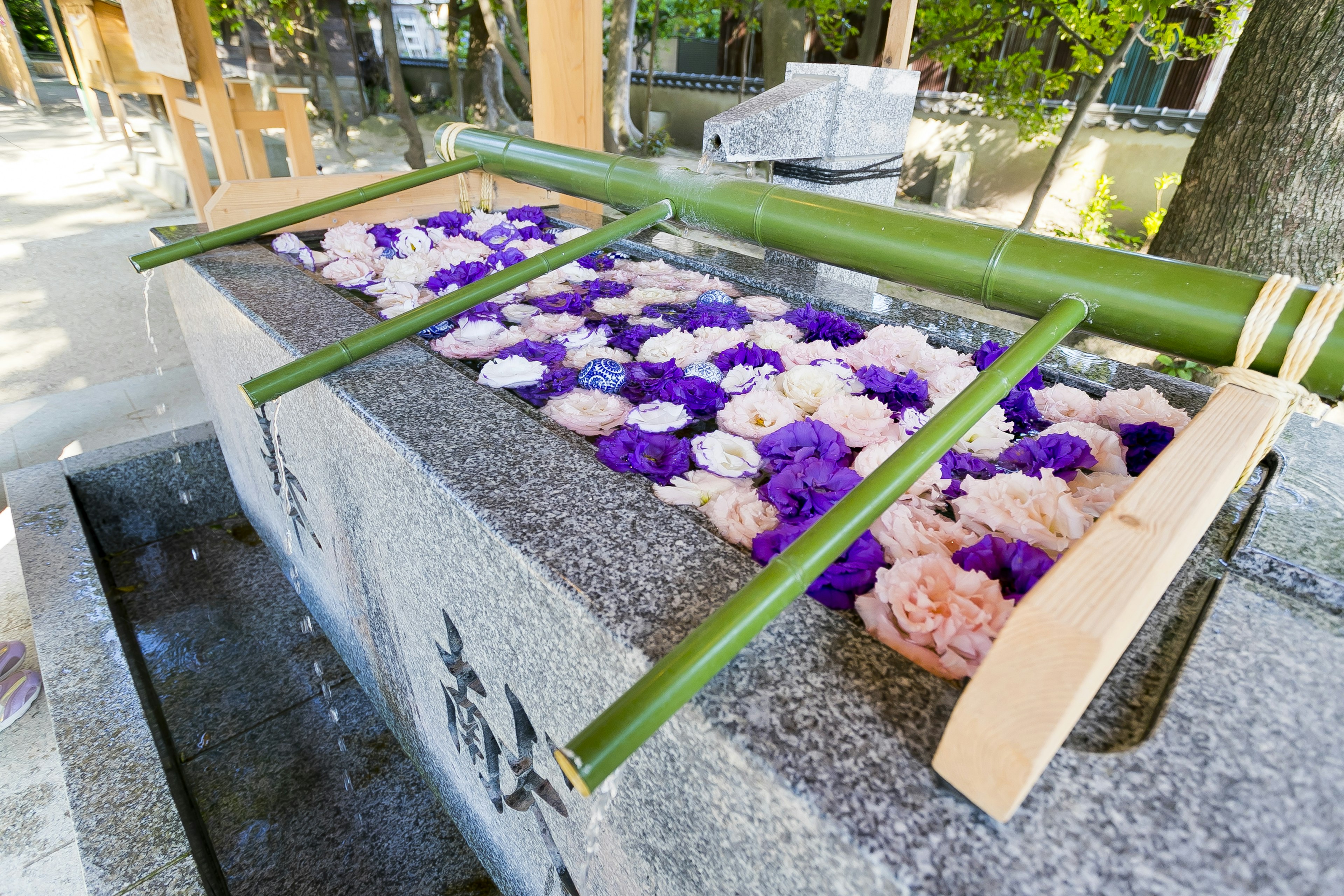 Una superficie de piedra adornada con flores coloridas sostenidas por bambú