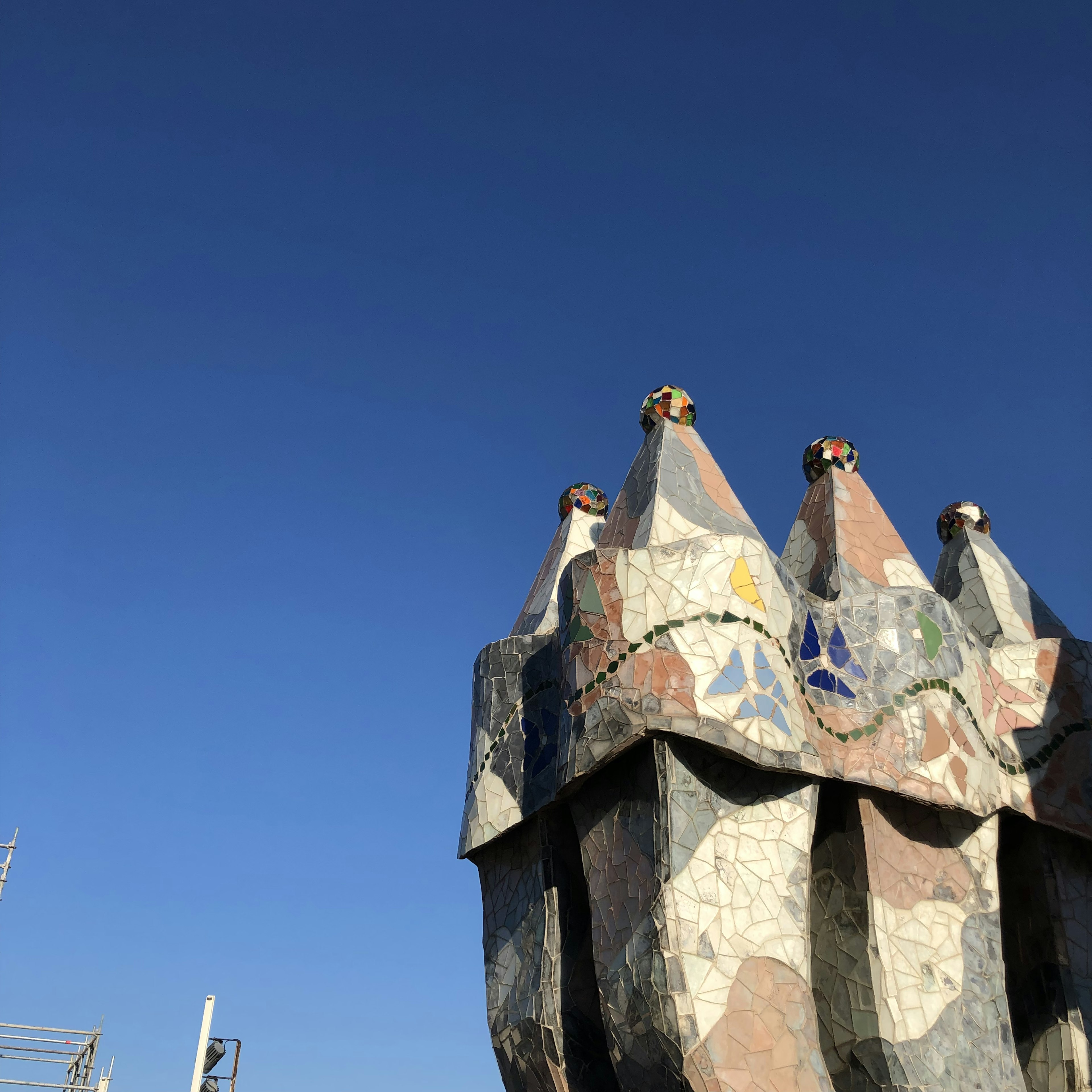 Einzigartige Schornsteinspitze, die mit bunten Mosaiken geschmückt ist, vor einem klaren blauen Himmel