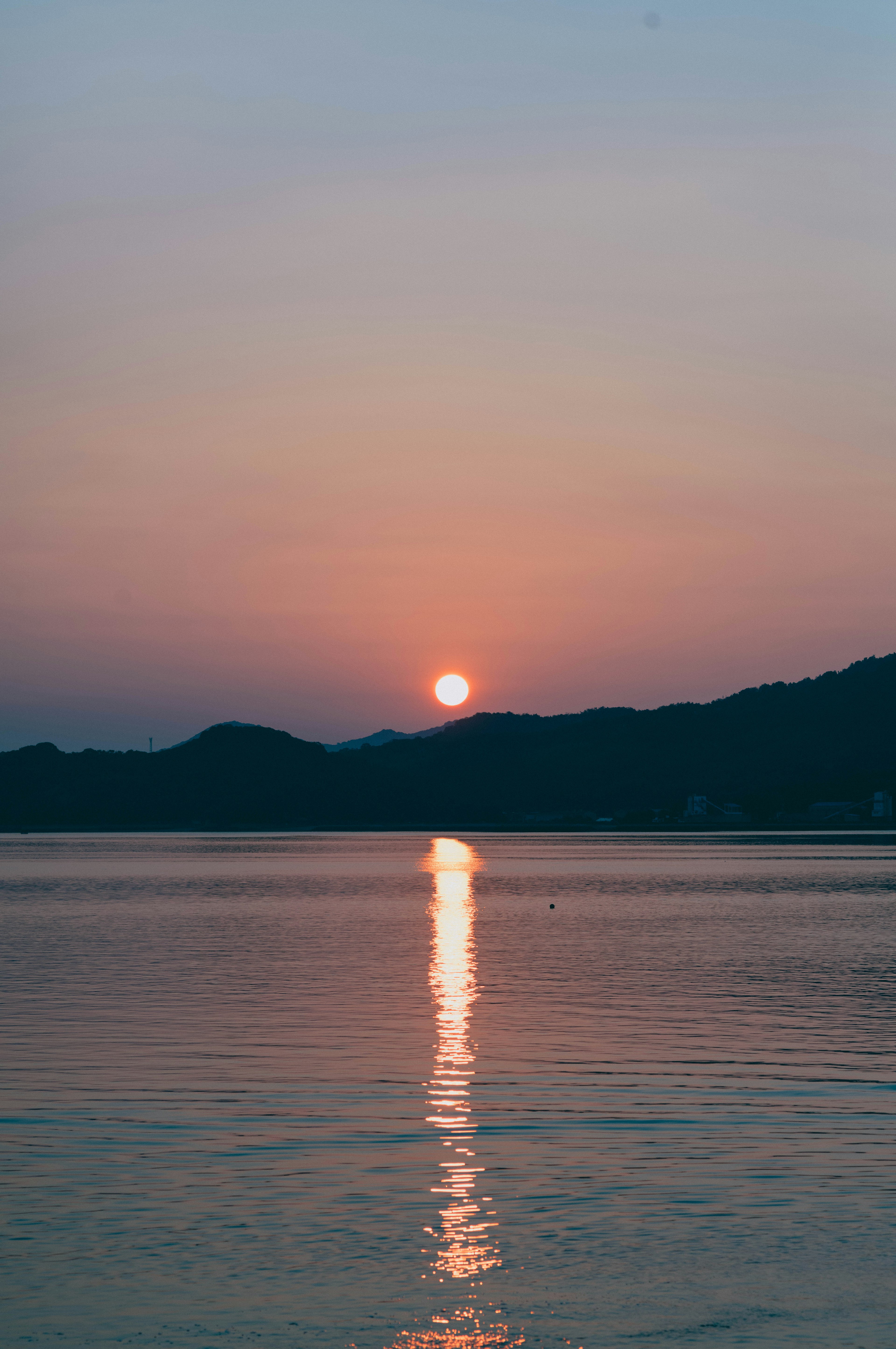 静かな湖の上に沈む夕日とその反射