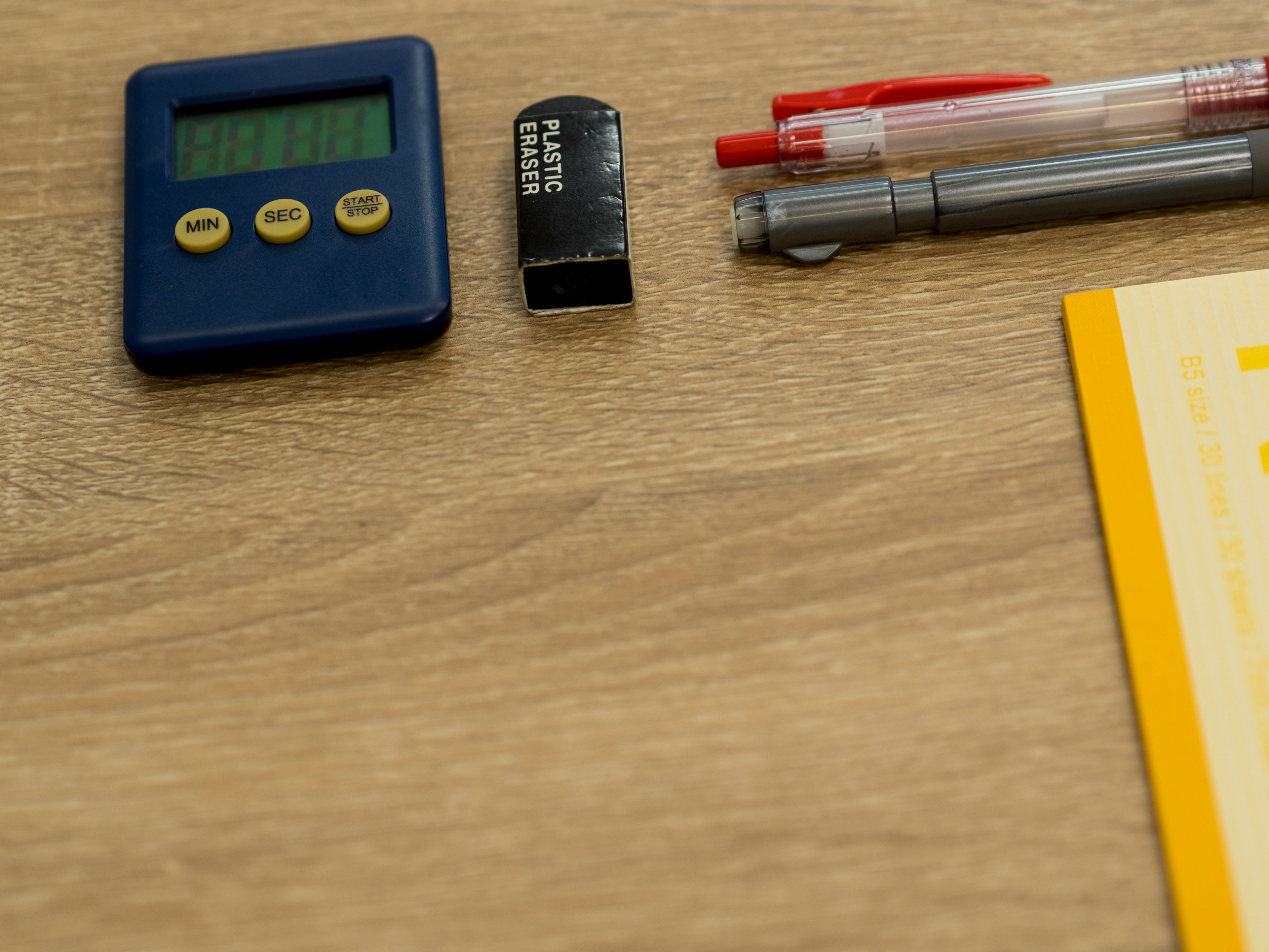 A desk scene featuring a timer and stationery items