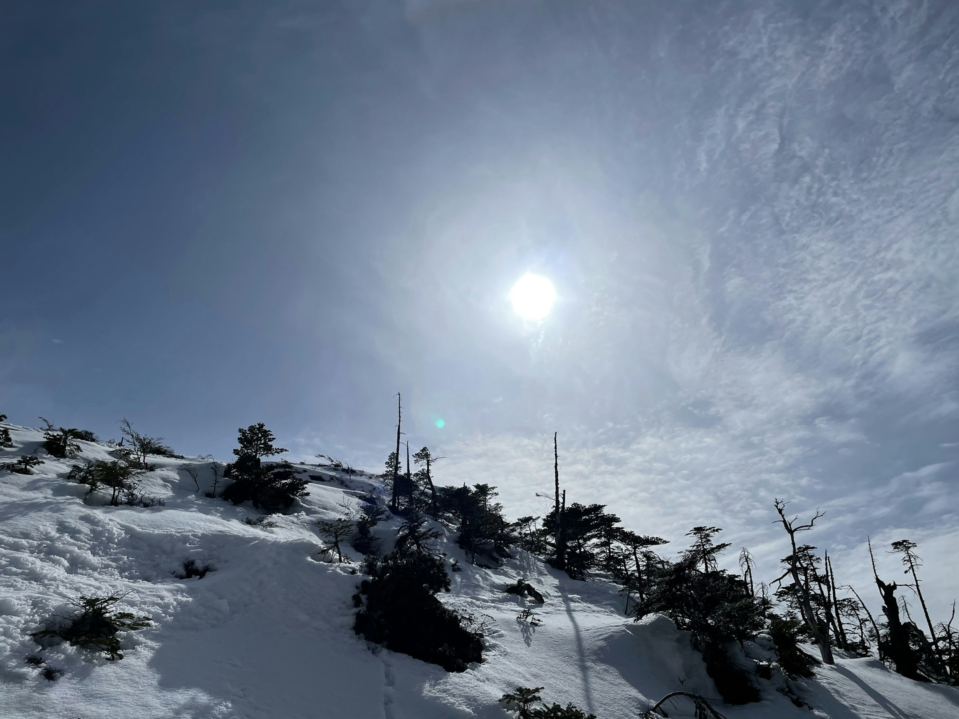 被雪覆盖的山脉和明亮的太阳