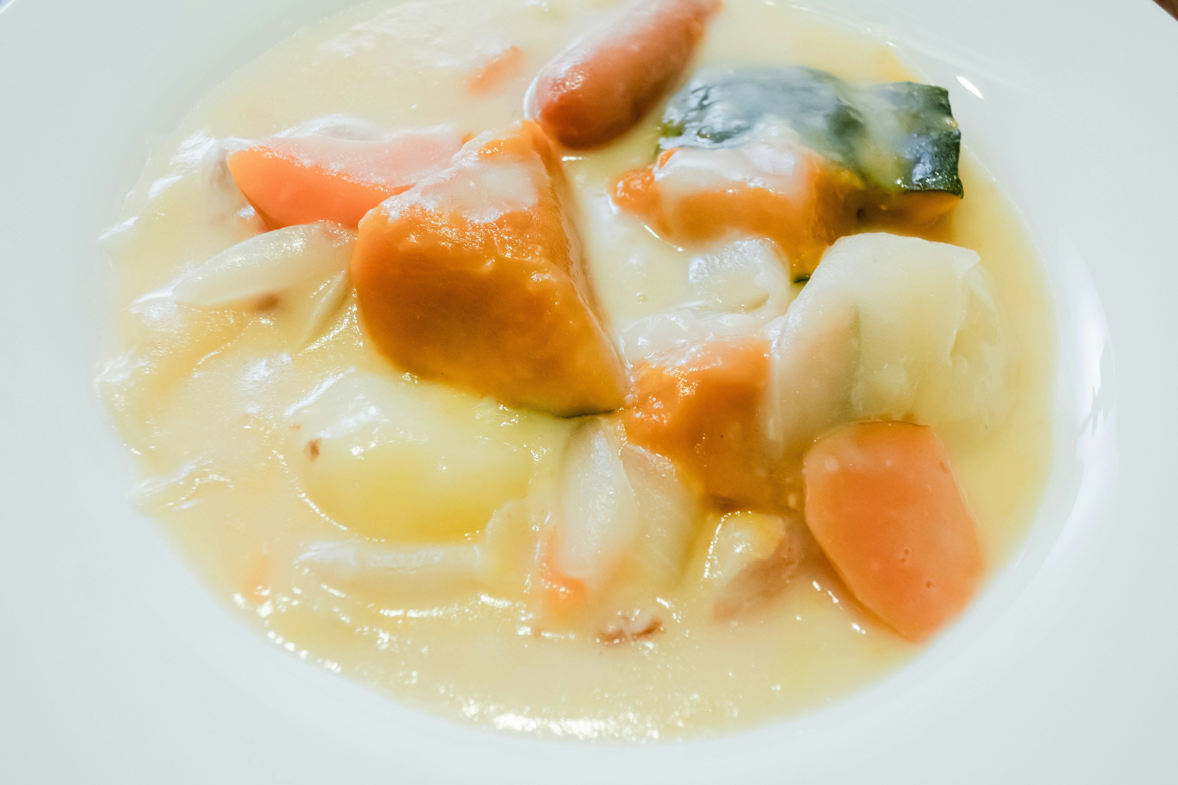 Sopa cremosa de verduras con trozos de zanahoria y calabaza