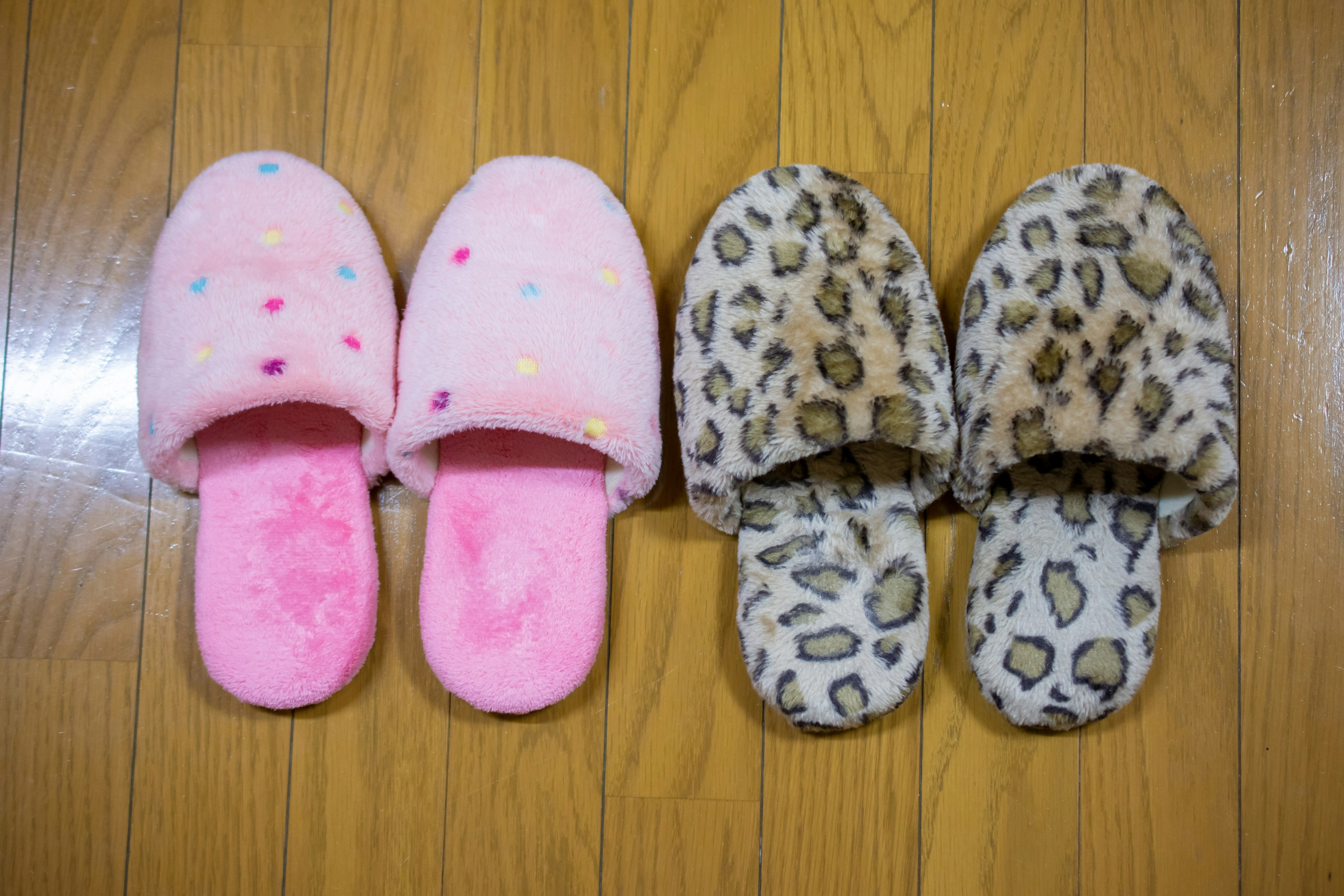 Pink dotted slippers and leopard print slippers arranged side by side