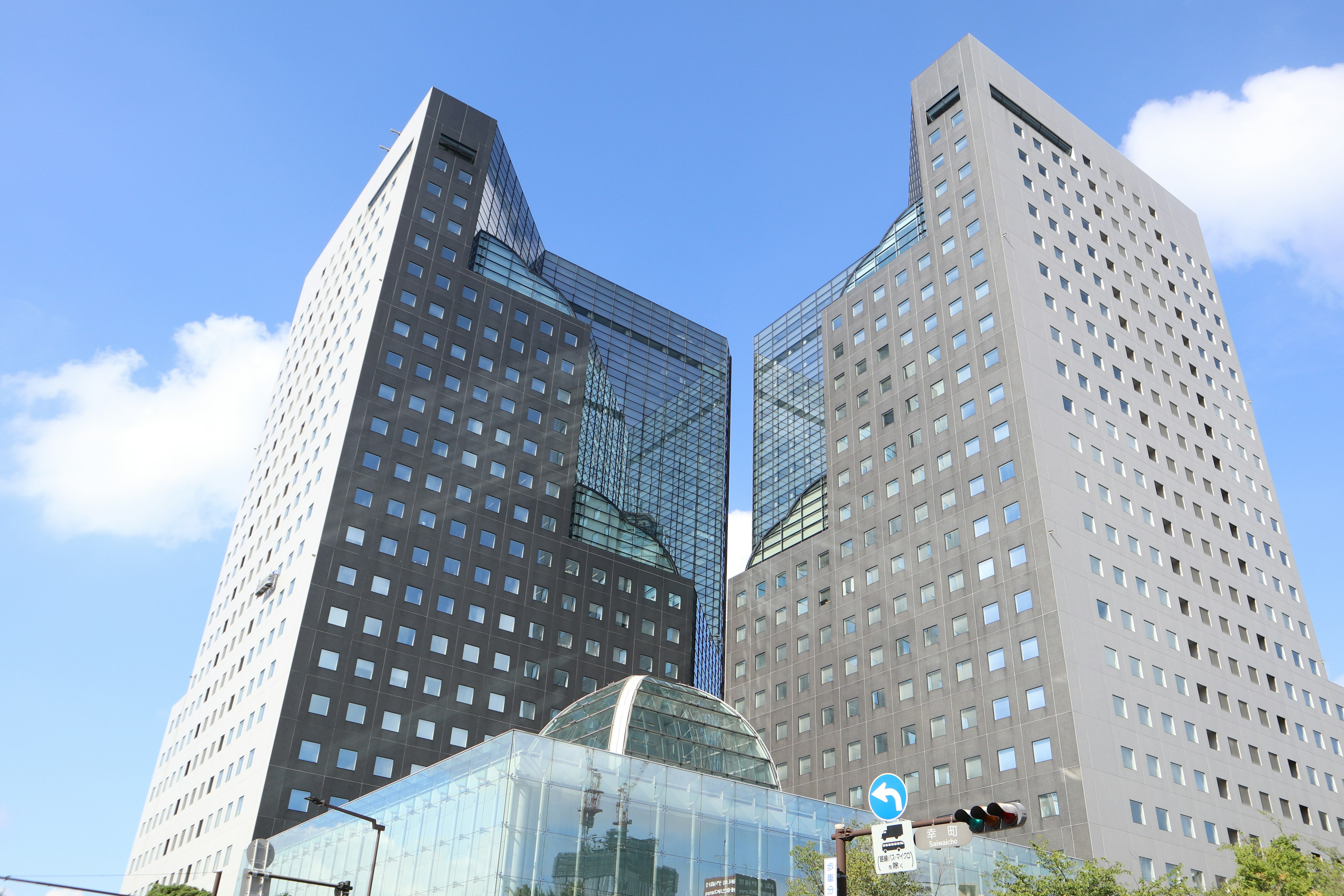 Two modern skyscrapers with glass structures and unique designs