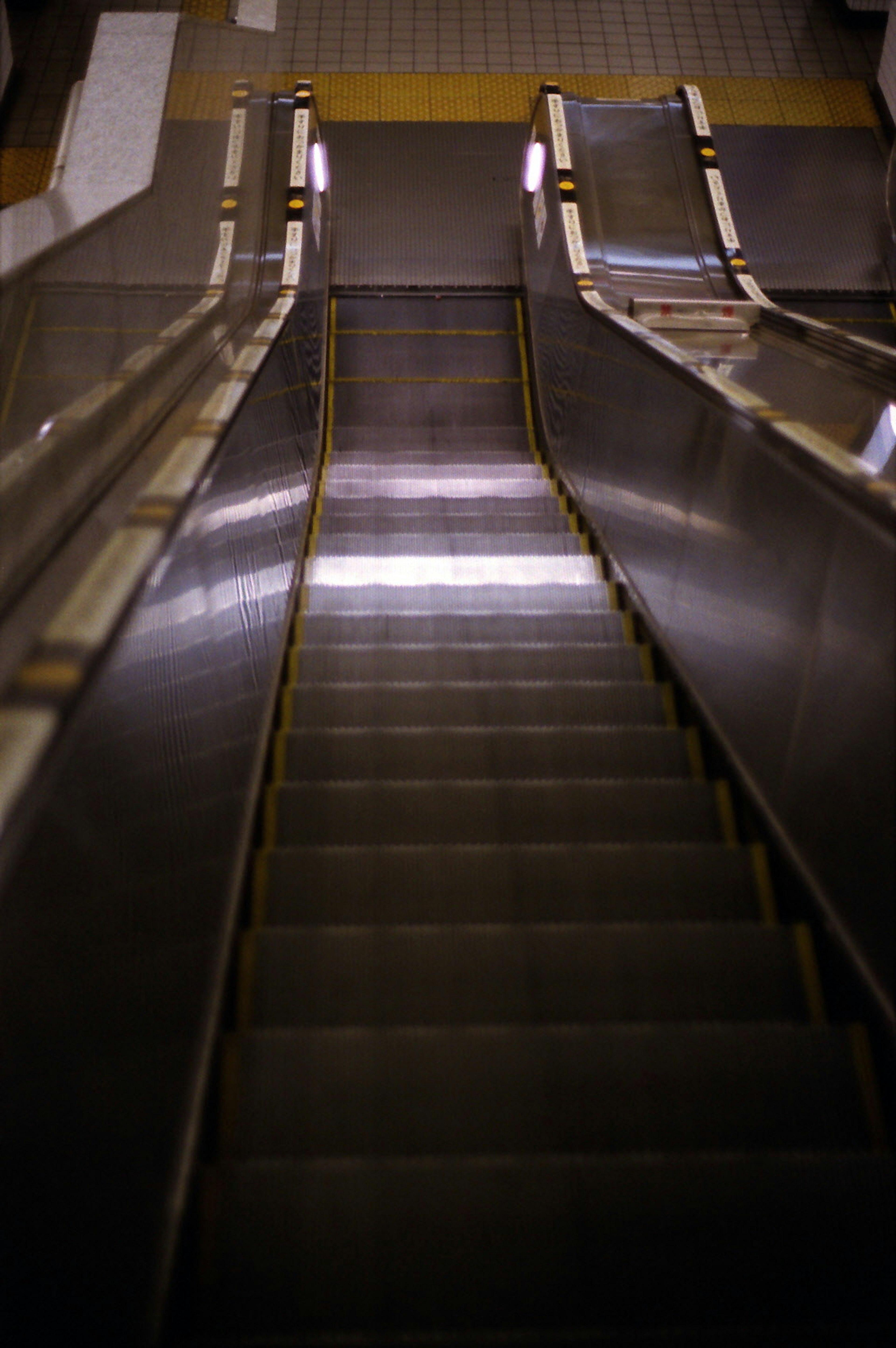 Photo showing an escalator viewed from the bottom looking up