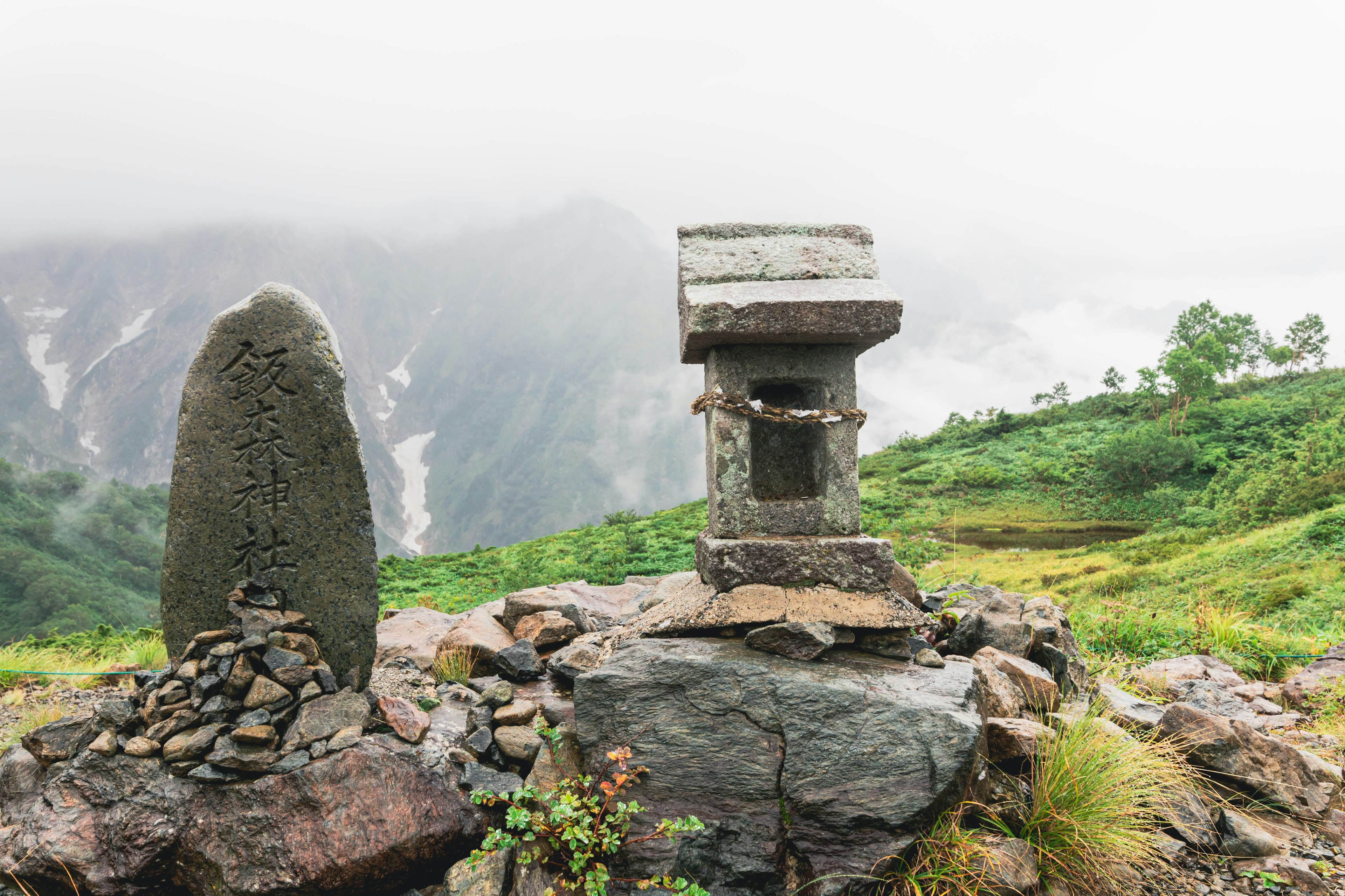 Malersicher Blick auf ein Steindenkmal und eine Felsenstruktur im Nebel