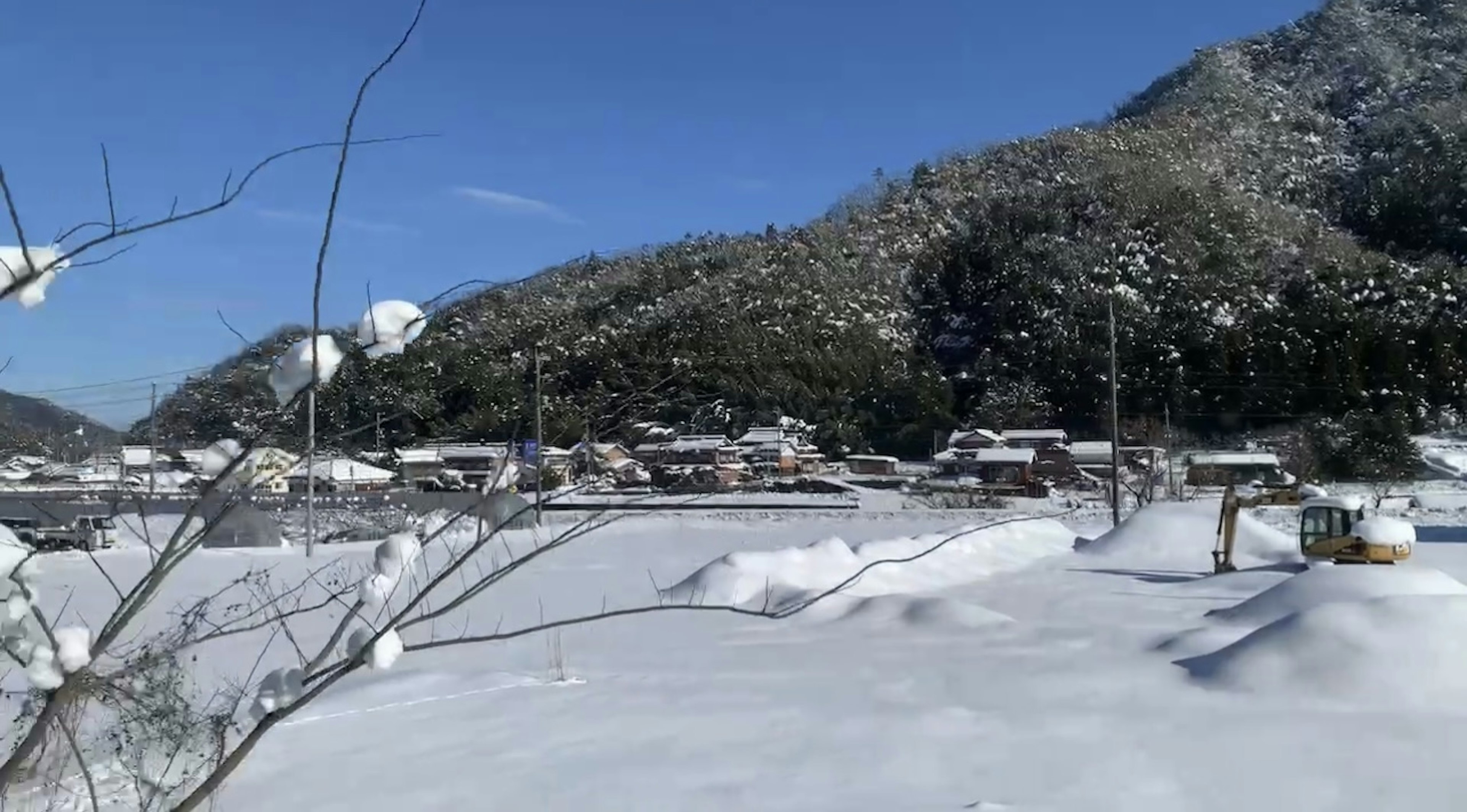 Paesaggio innevato con un villaggio montano sotto un cielo azzurro