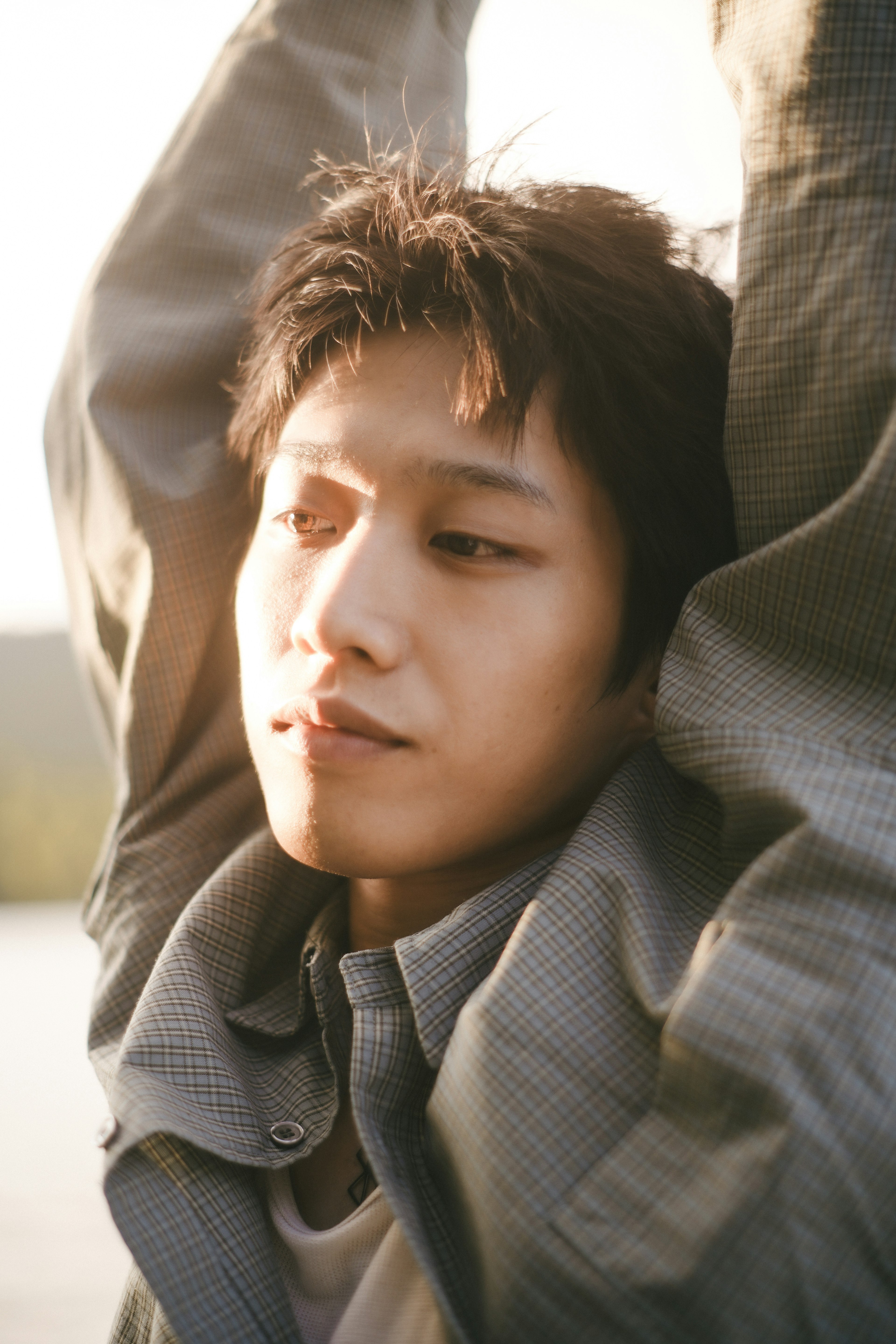 Jeune homme avec une expression calme se relaxant au soleil