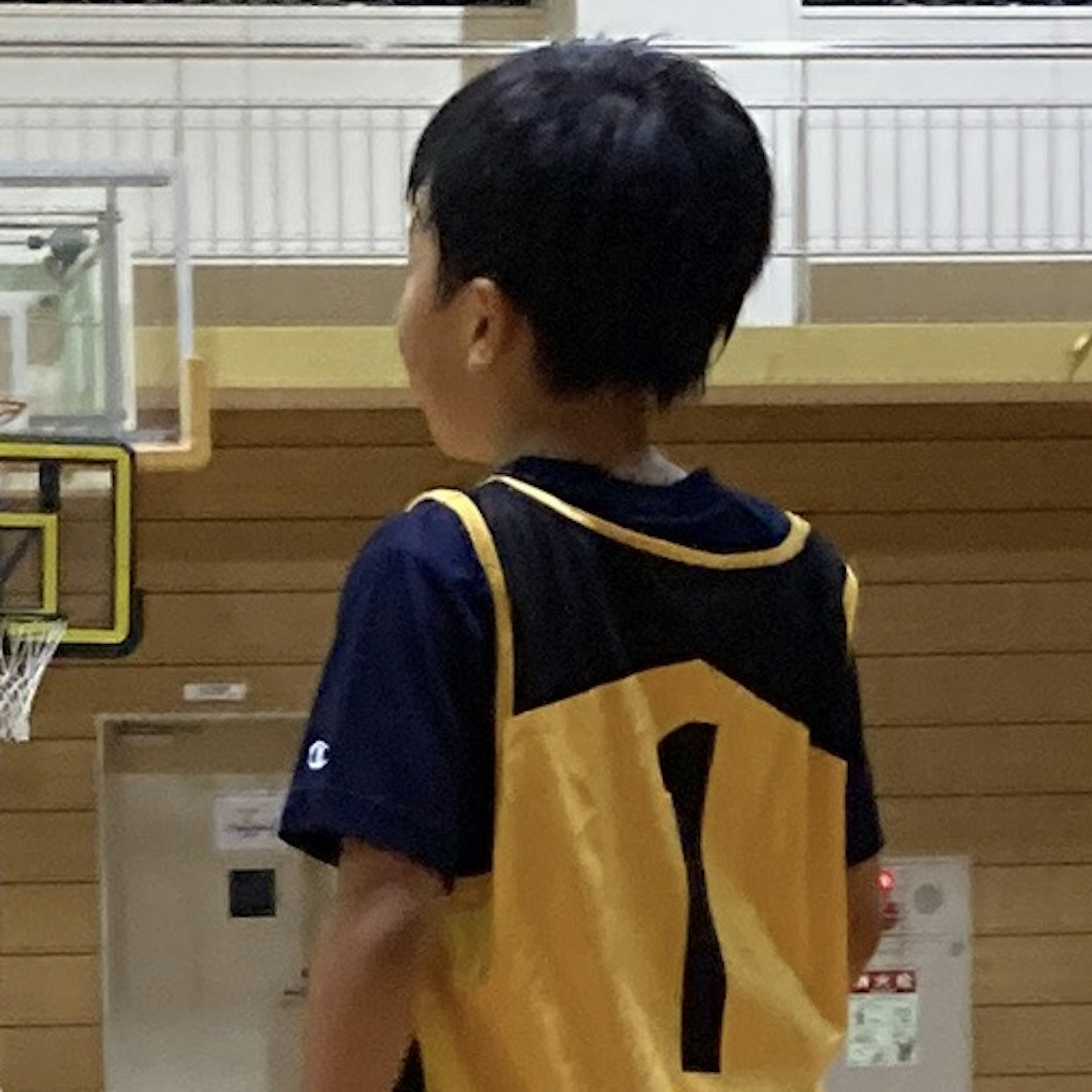 Niño con camiseta de baloncesto de pie de espaldas