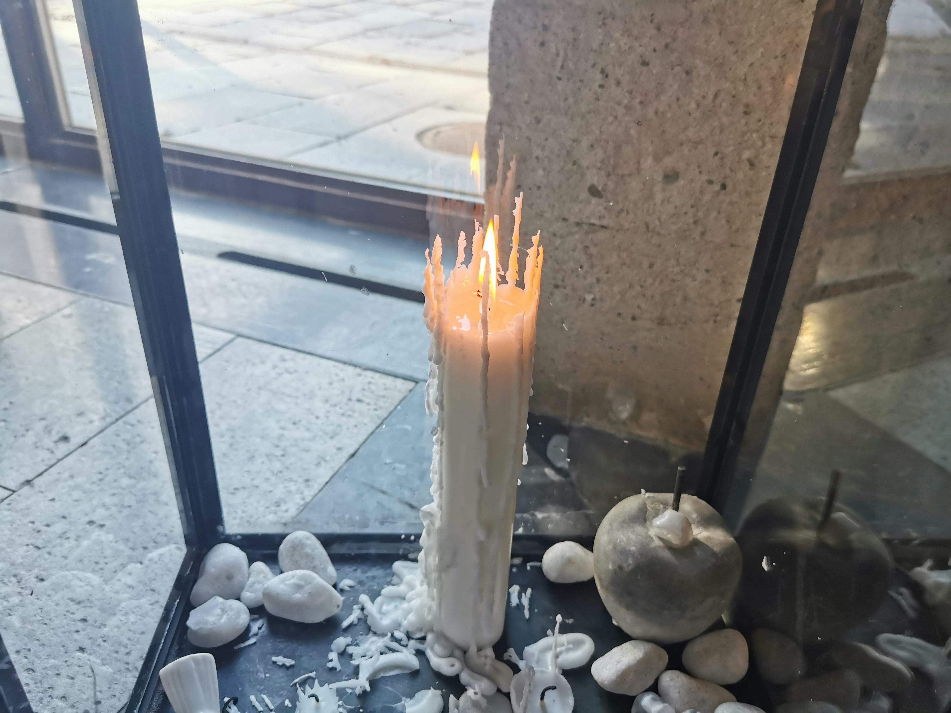 Una vela blanca ardiendo en un entorno decorativo minimalista