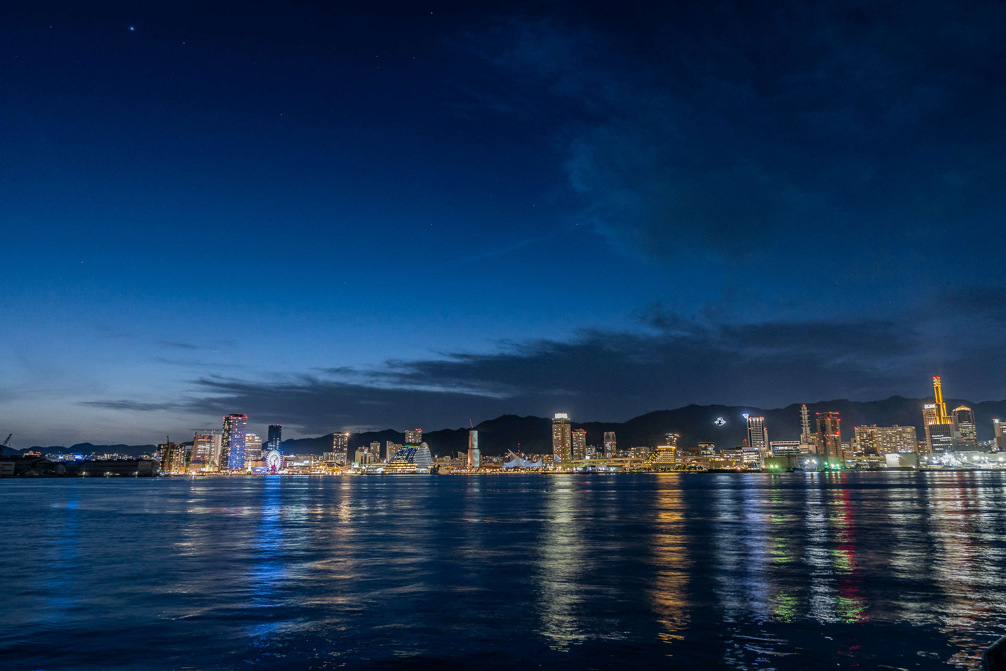 hermosa reflexión del horizonte nocturno de una ciudad en el agua