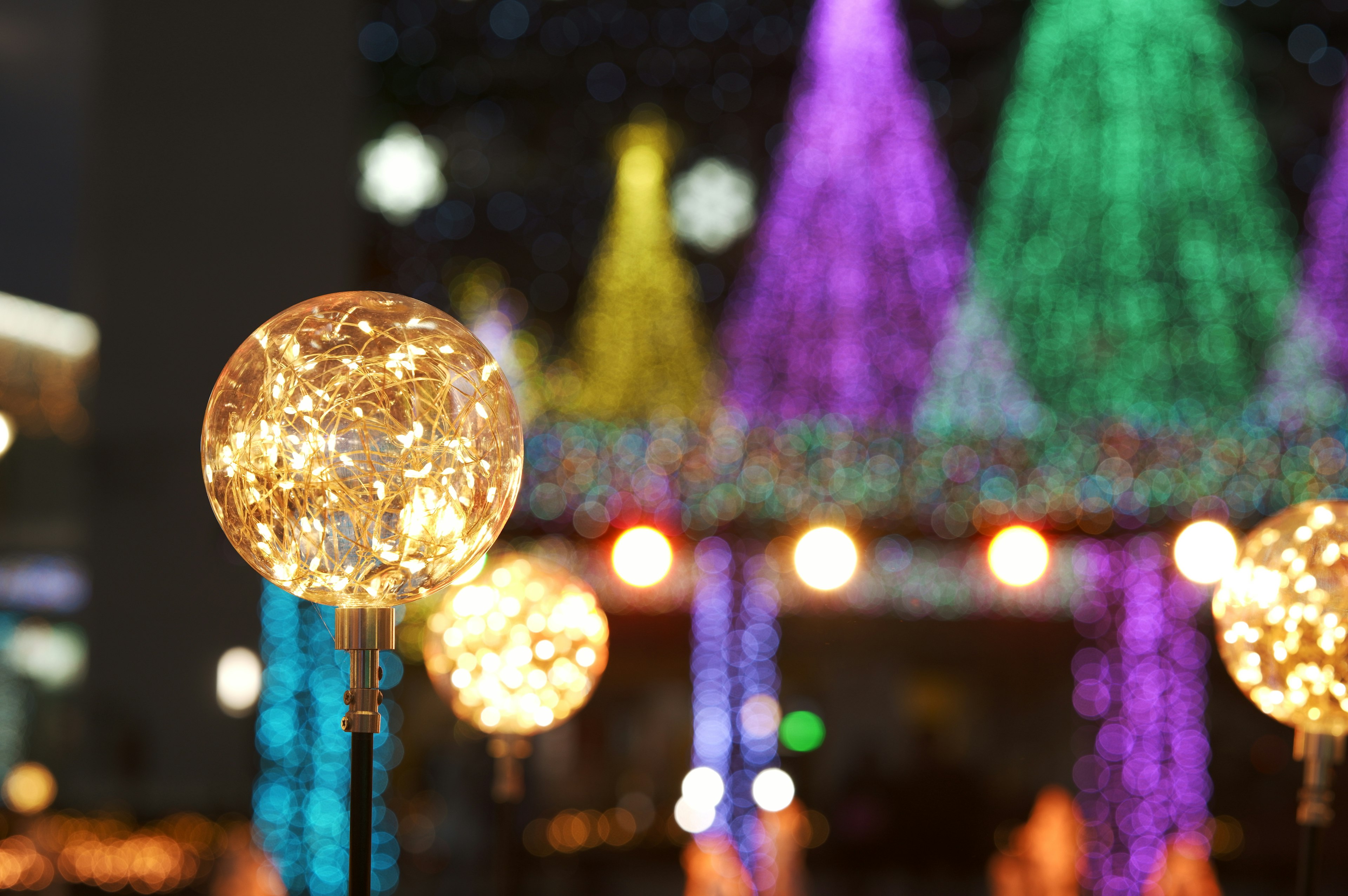 Sphères décoratives lumineuses avec des lumières colorées en arrière-plan