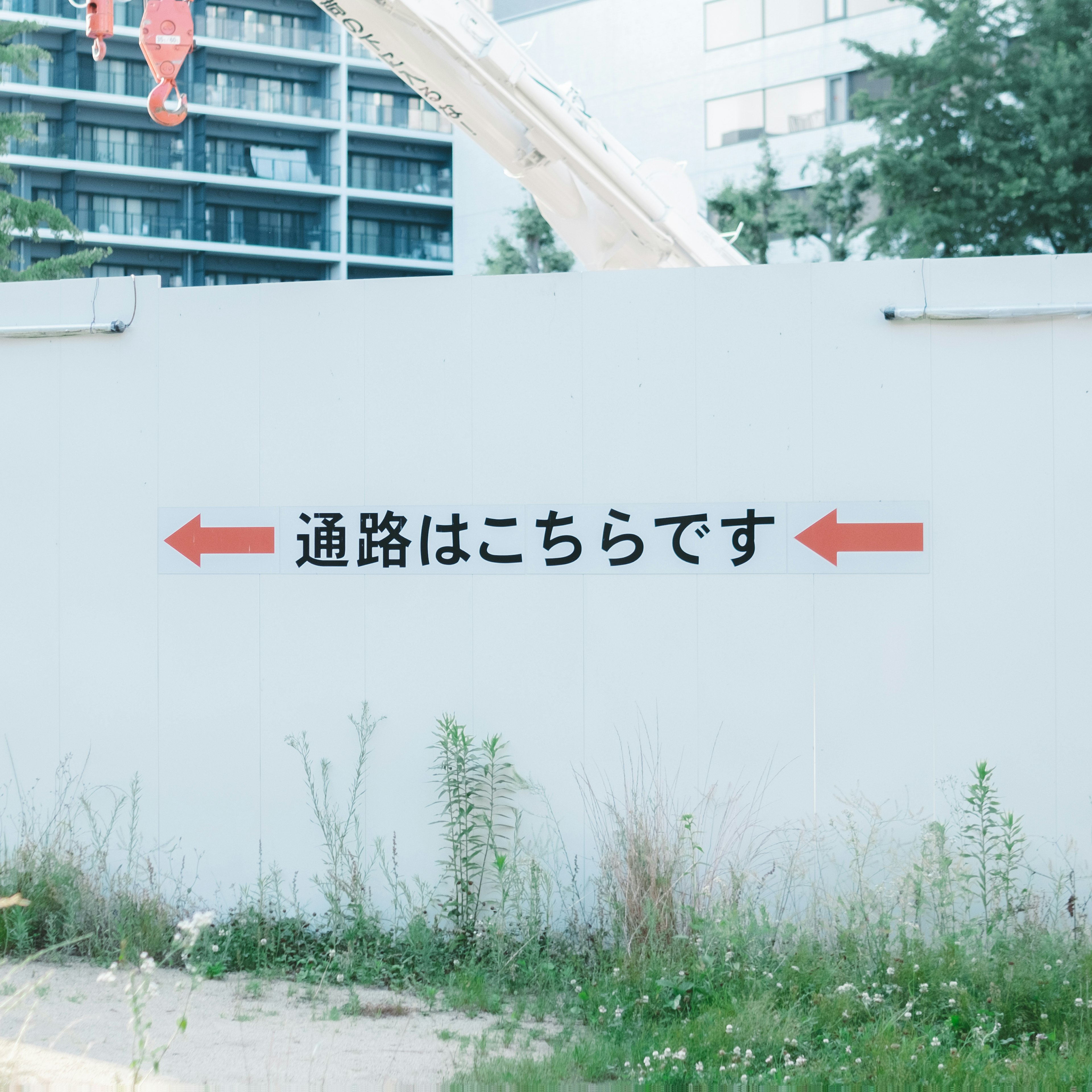 Mur blanc avec des flèches indiquant un chemin en japonais