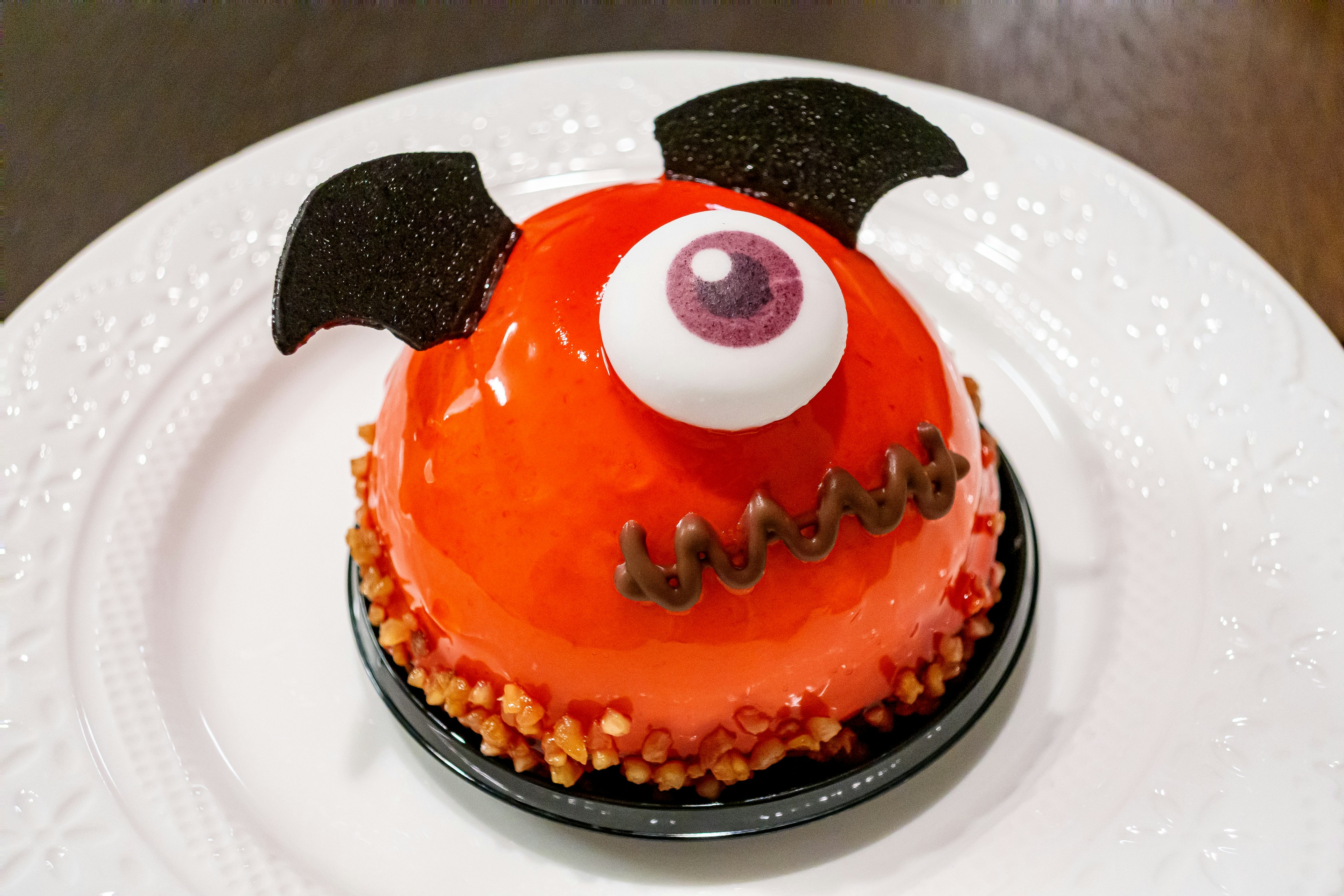 Orange monster cake with black ears and a large eye