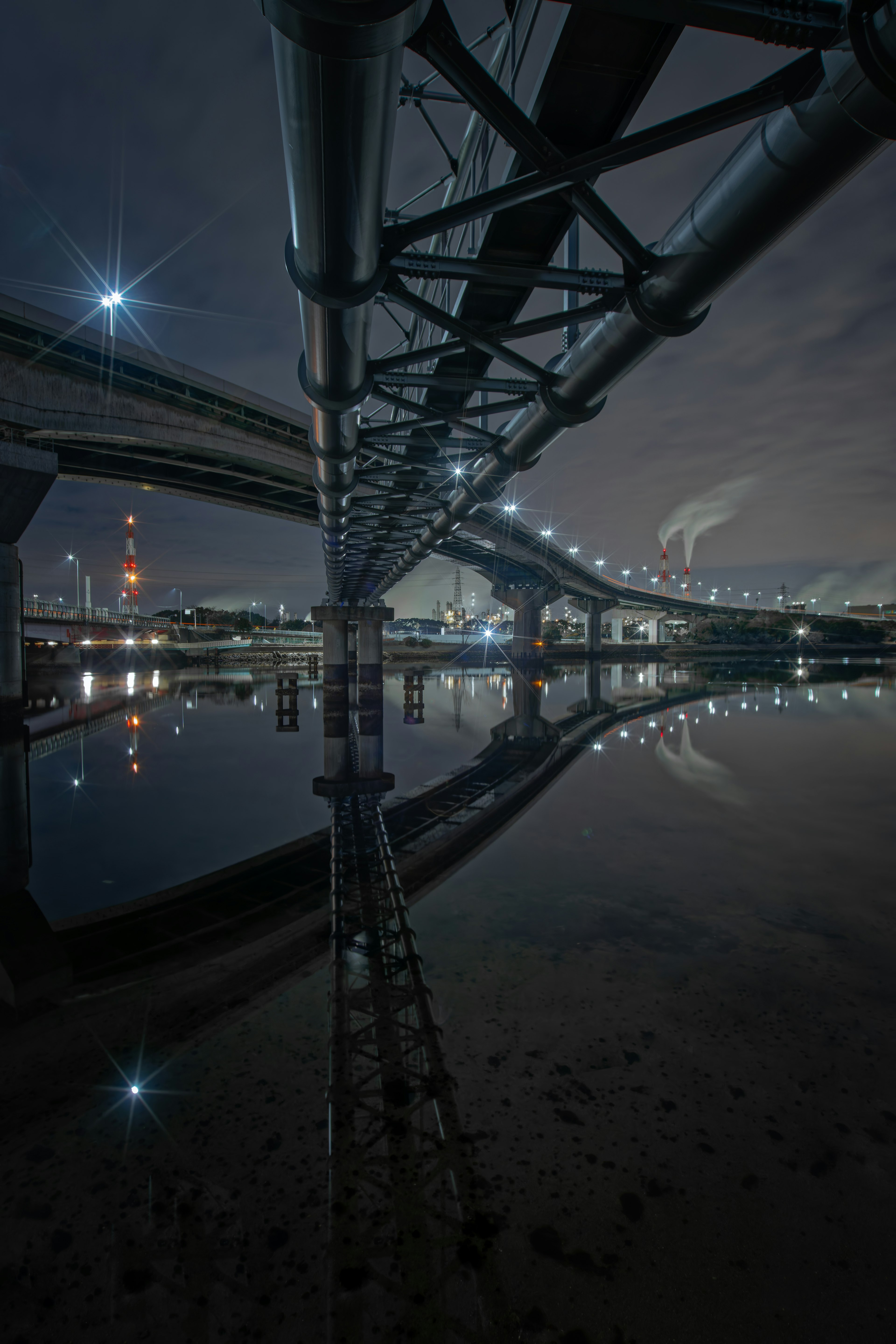 Puente urbano de noche con reflejos en el agua