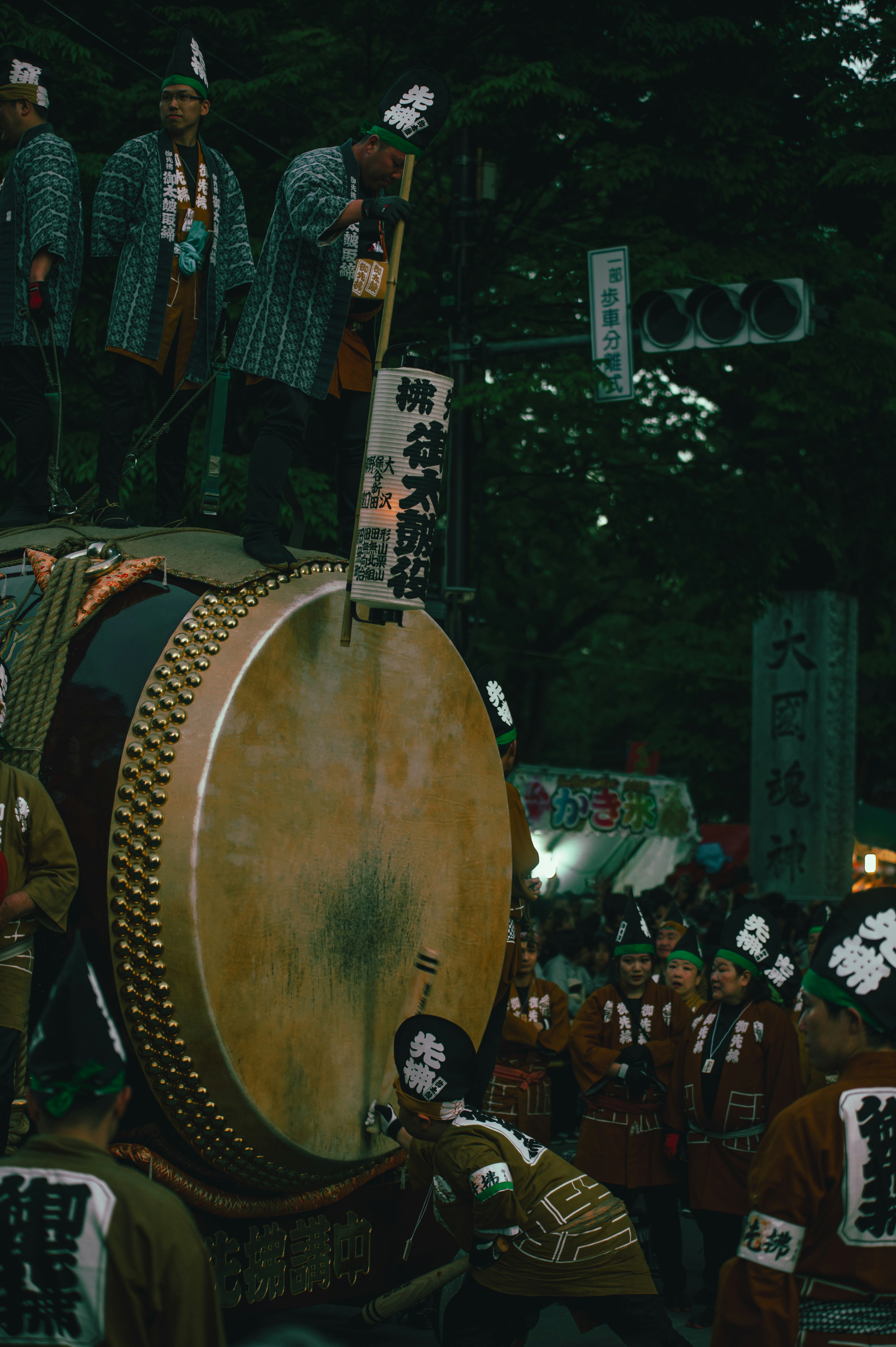 People playing a festival drum with participants in traditional clothing