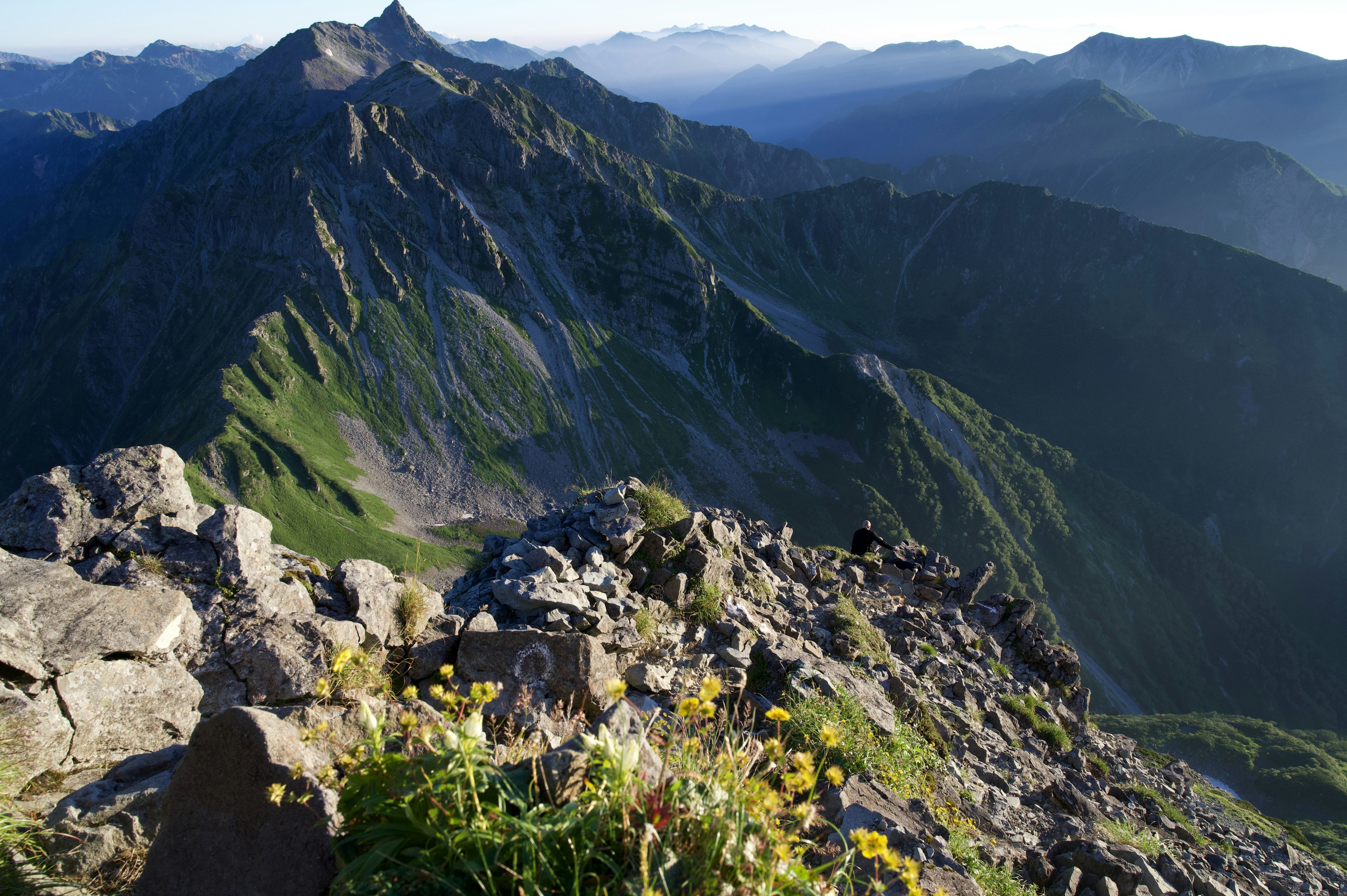 Landschaftsansicht von grünen Bergen mit blühenden gelben Blumen im felsigen Gelände