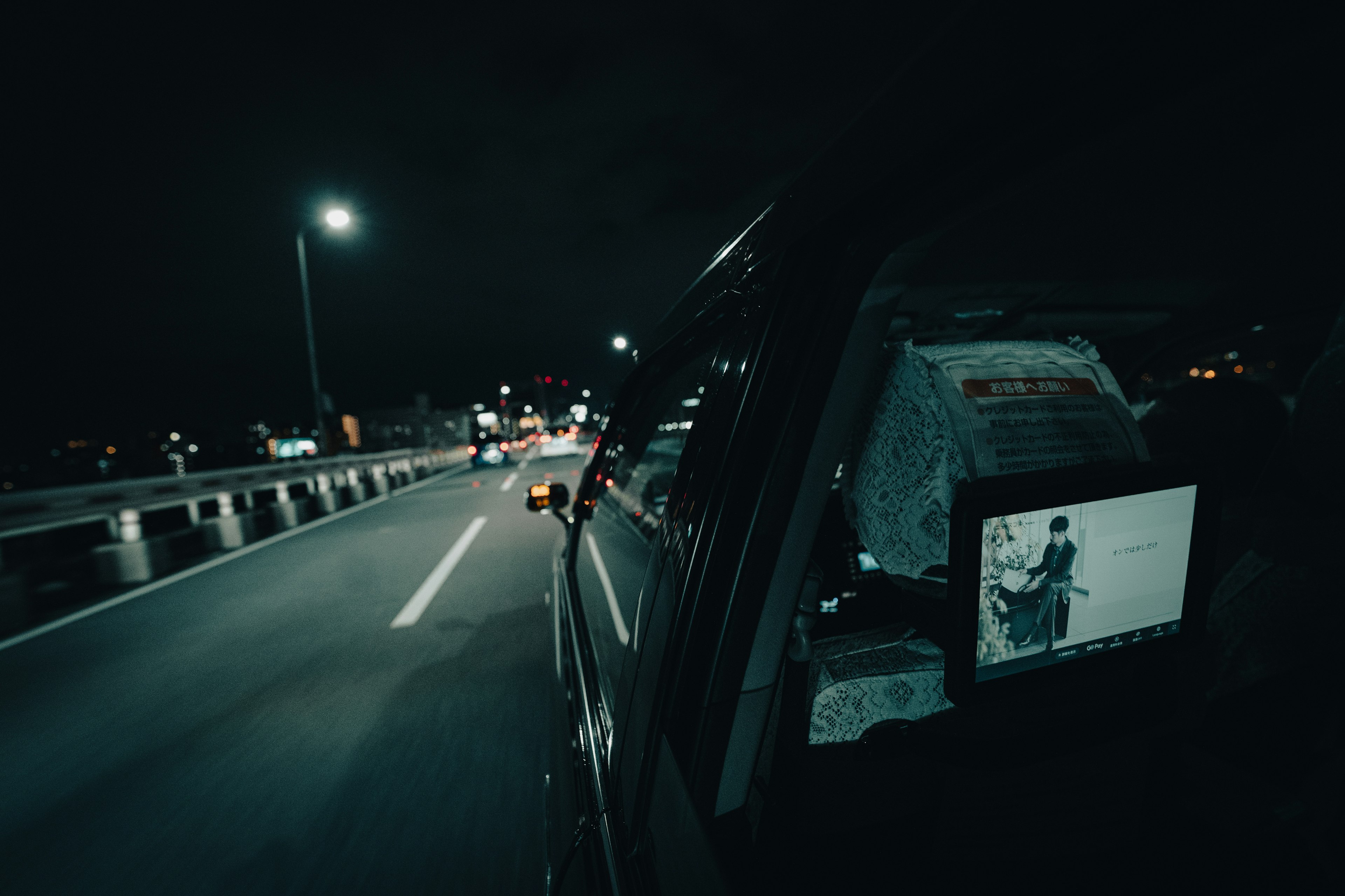 Vue depuis la fenêtre d'une voiture montrant une route nocturne et un ordinateur portable