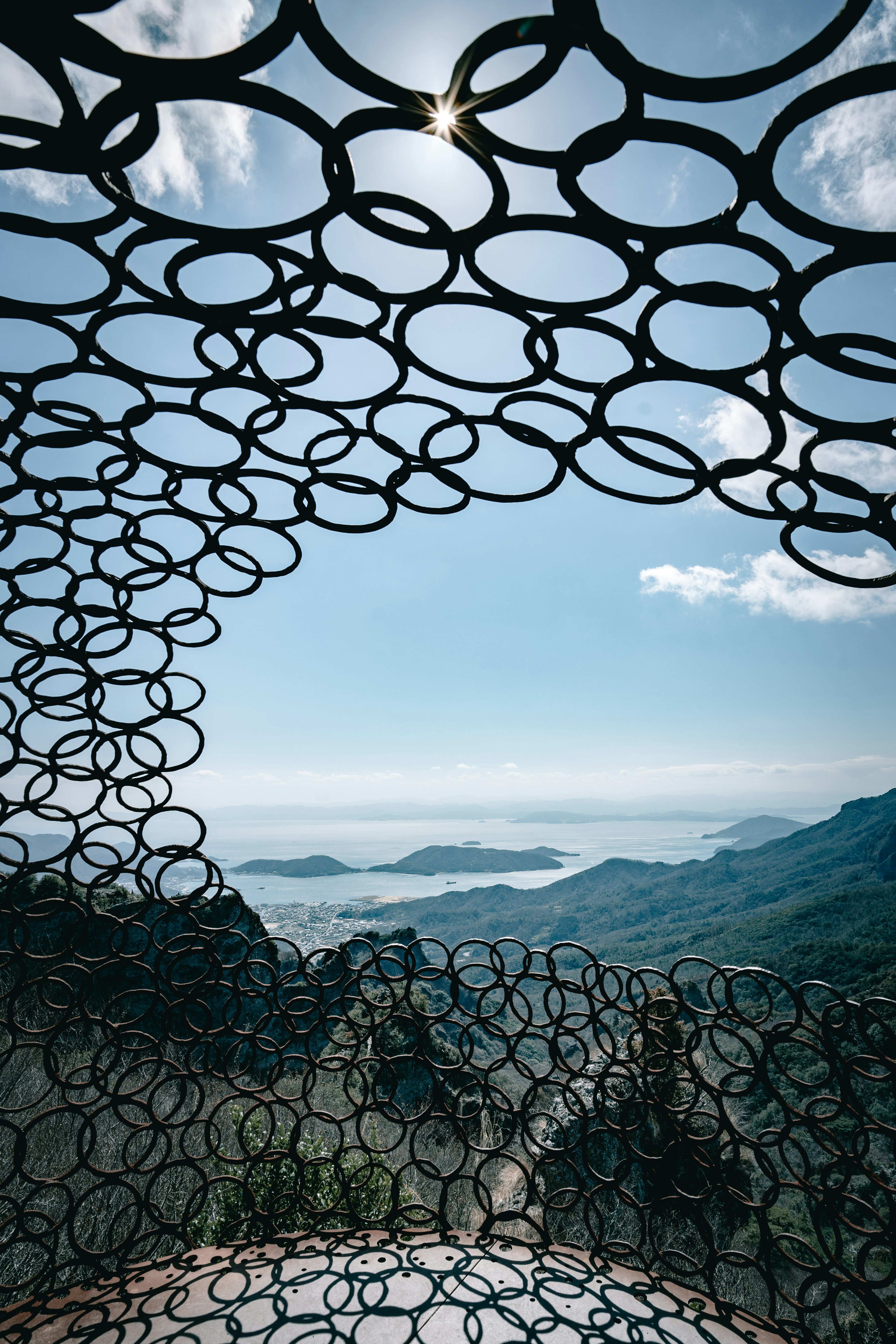 Vista desde el interior de una estructura circular que mira hacia montañas y mar