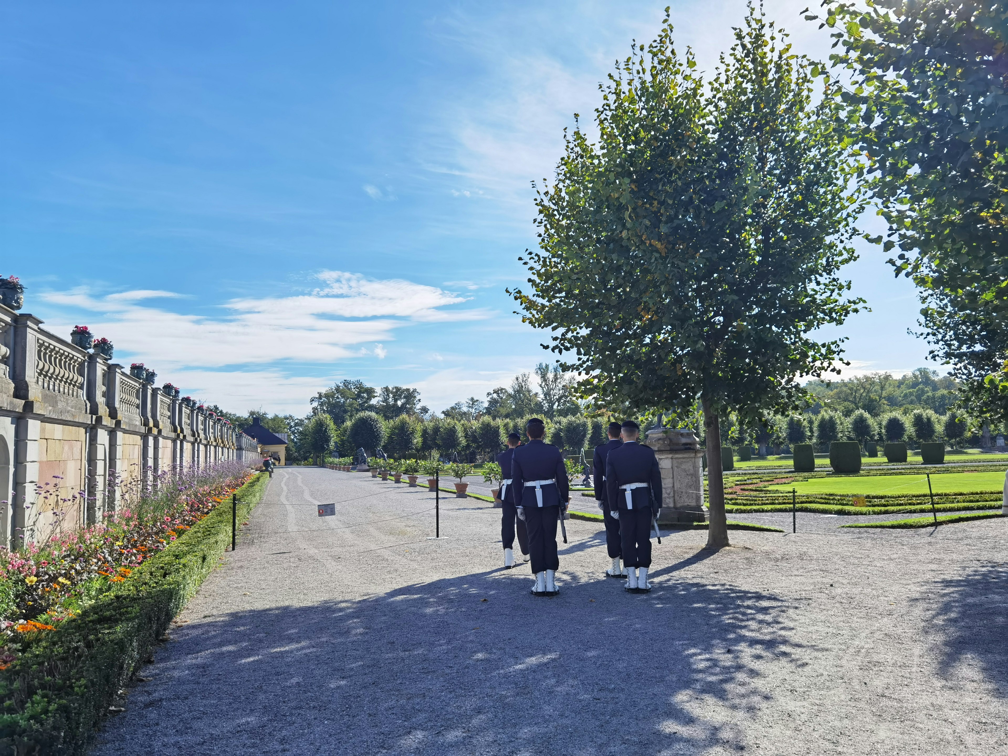 Dos personas caminando en un jardín con vegetación exuberante