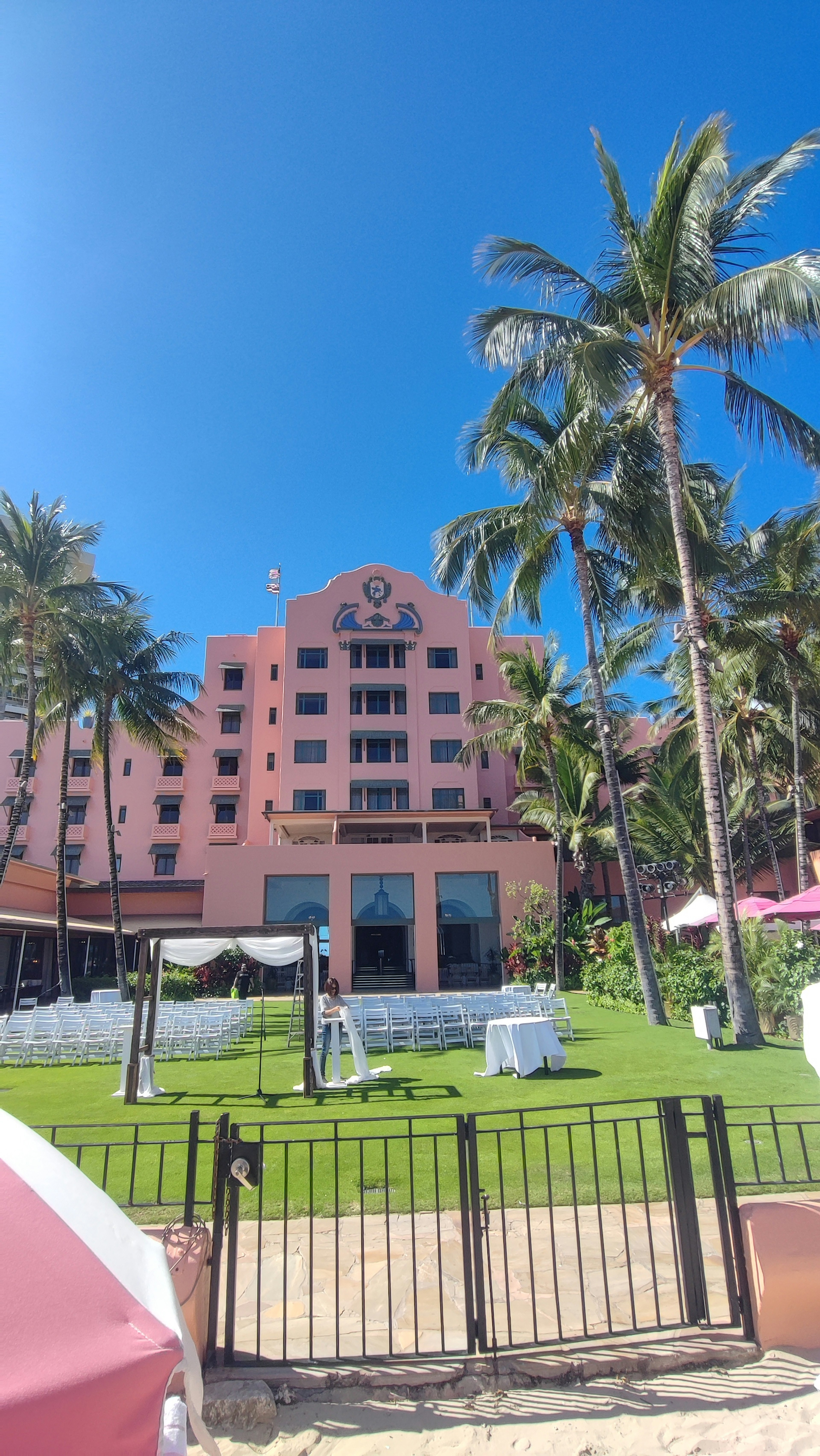 Hotel rosa cerca de la playa con palmeras