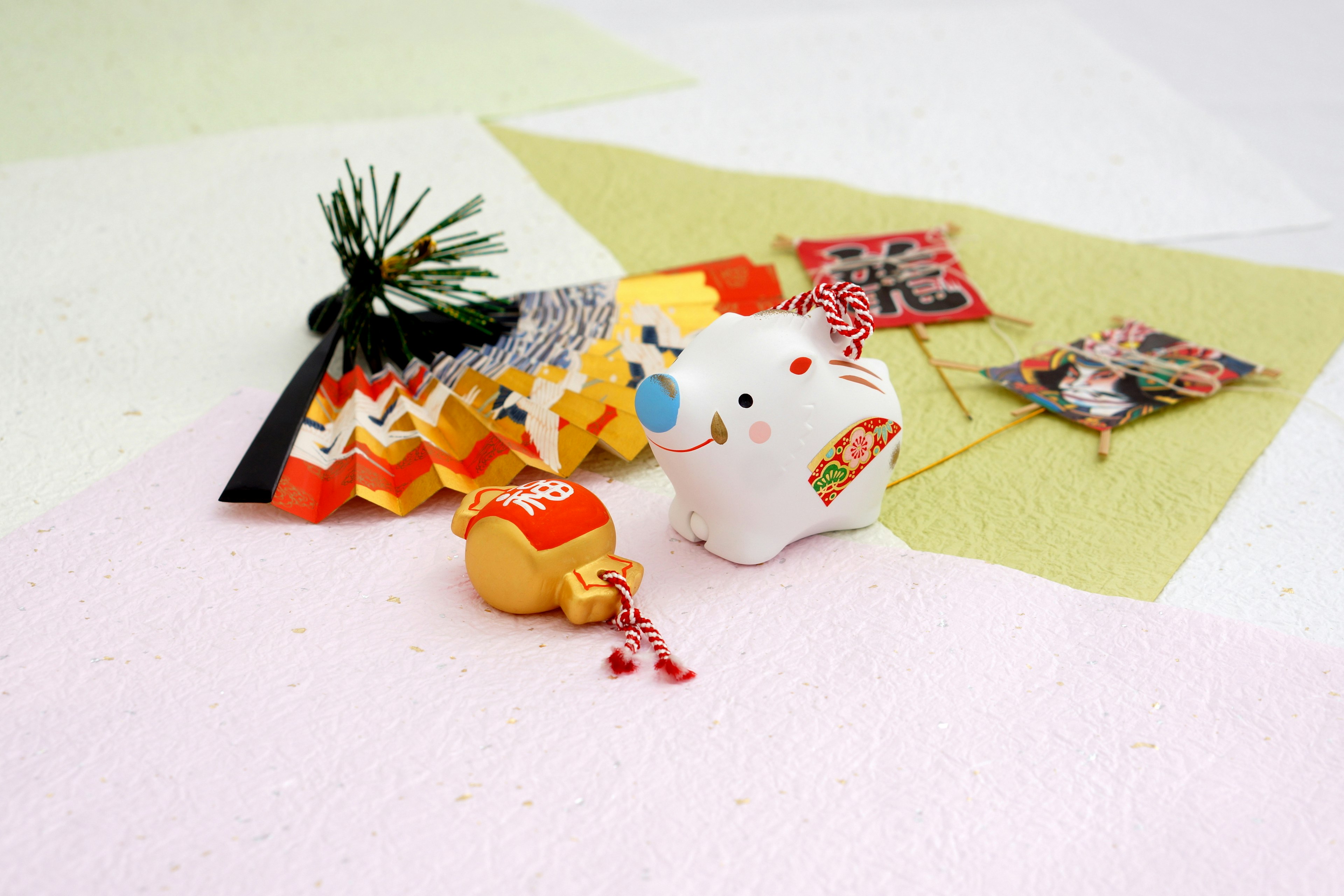 Objek tradisional Jepang berwarna-warni diatur dalam gambar Patung kucing putih di sebelah kanan Sisi dengan origami dan dekorasi Jepang di sebelah kiri