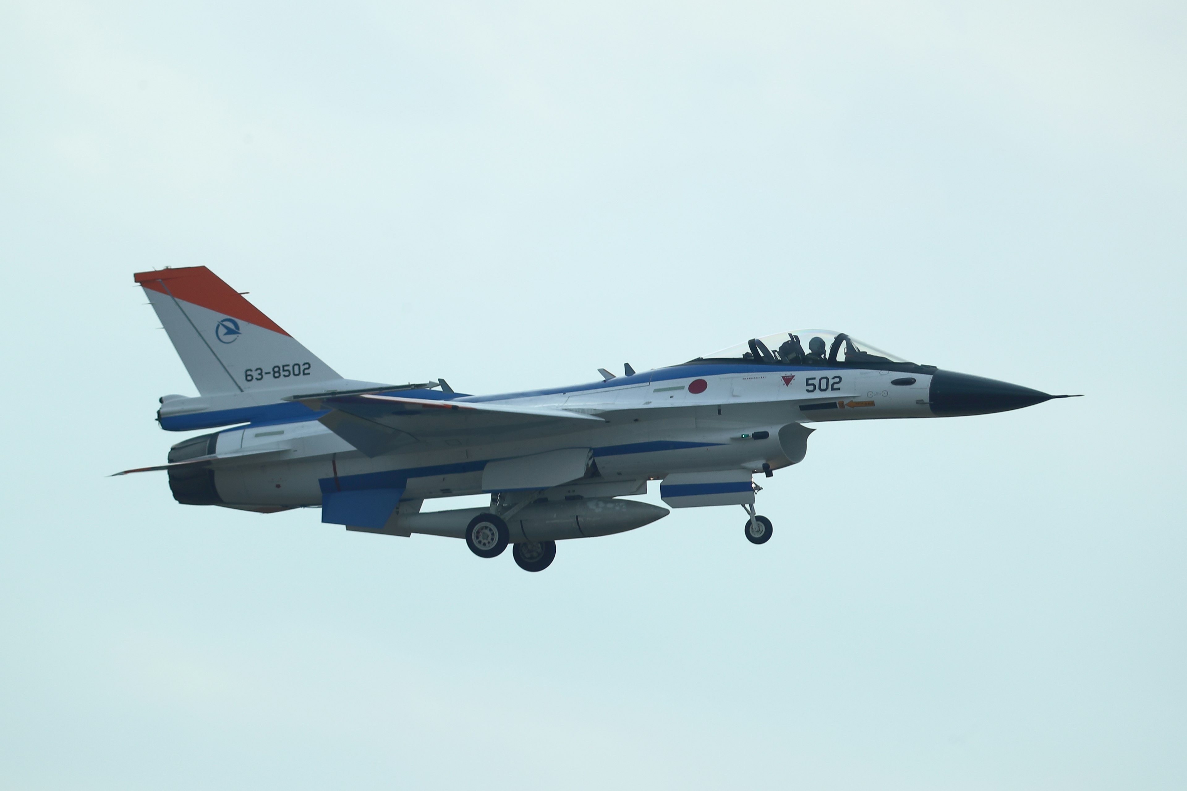 Blauer F-16 Kampfjet fliegt am Himmel