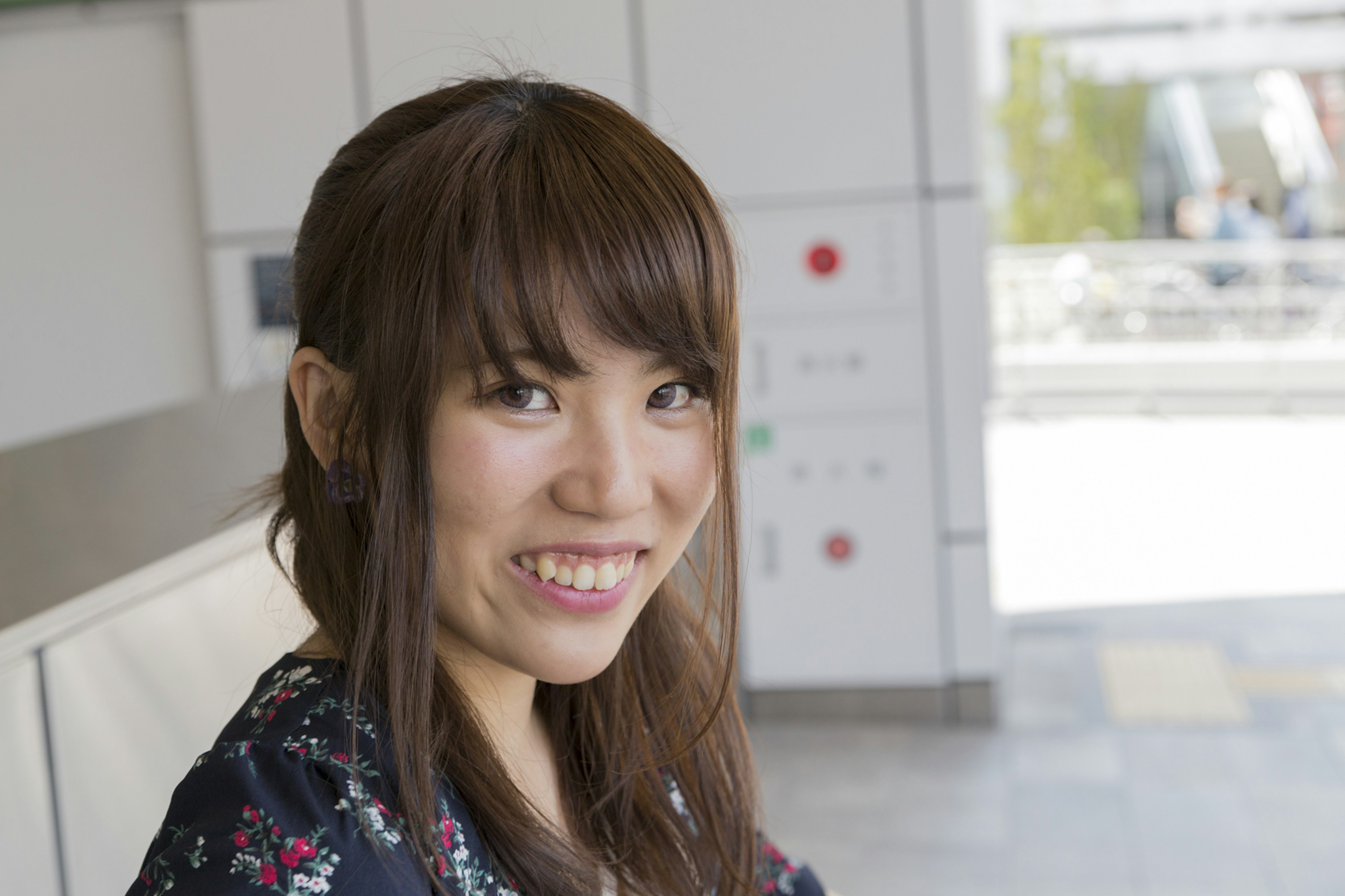 Young woman smiling and looking at the camera with bright building and natural light in the background