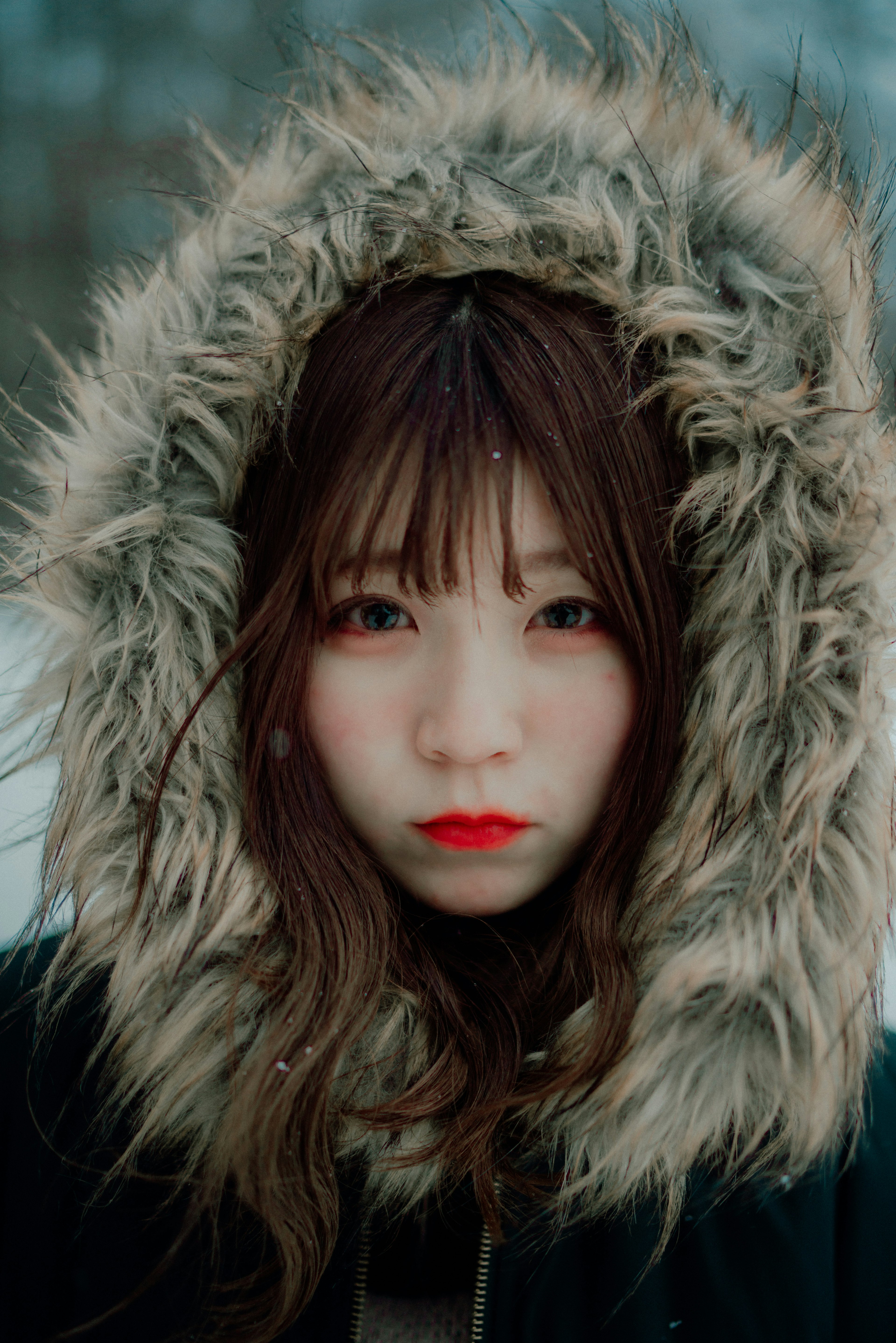 Portrait d'une femme dans un manteau à capuche en fourrure dans la neige