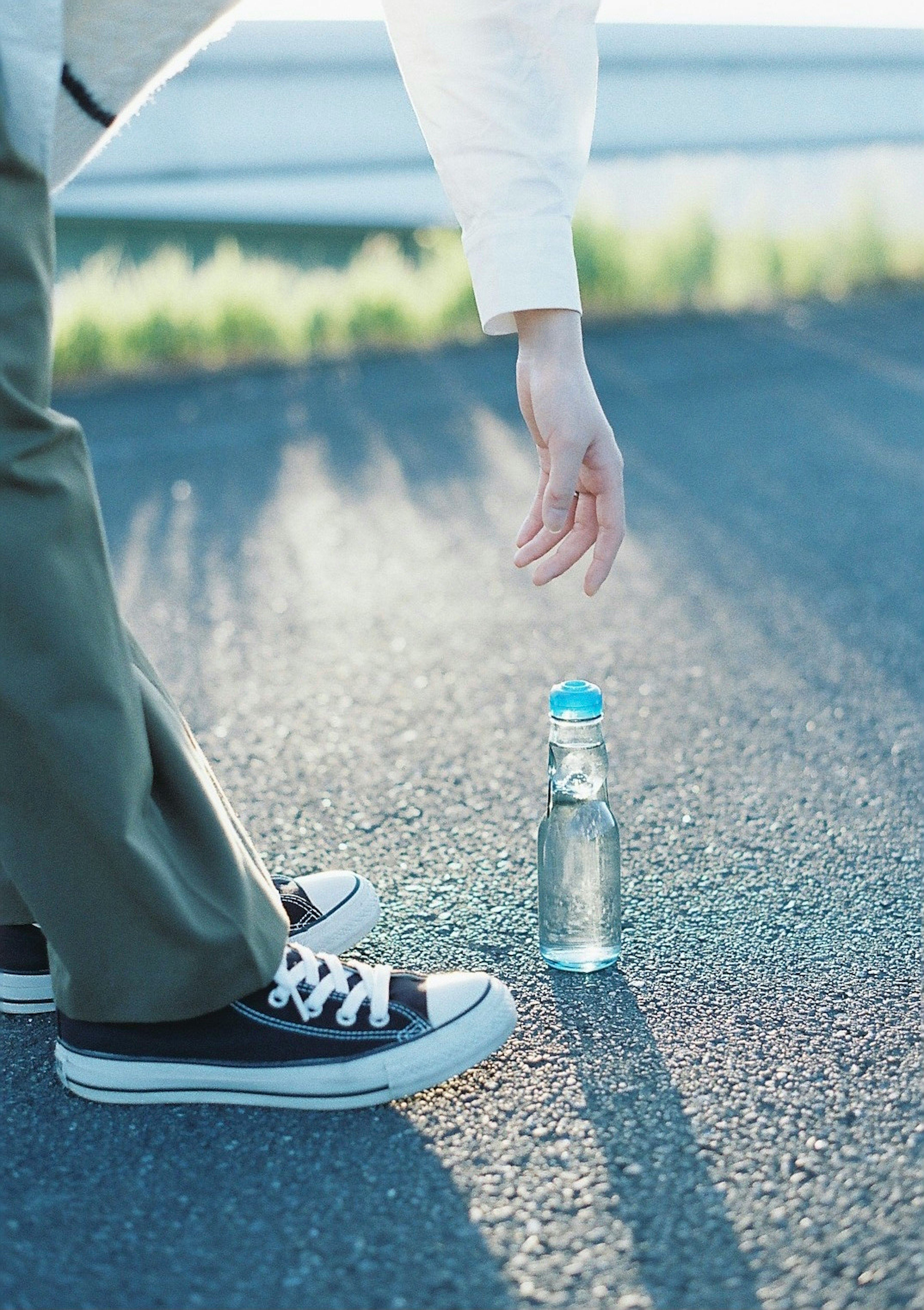 Mano che si avvicina a una bottiglia d'acqua sul pavimento