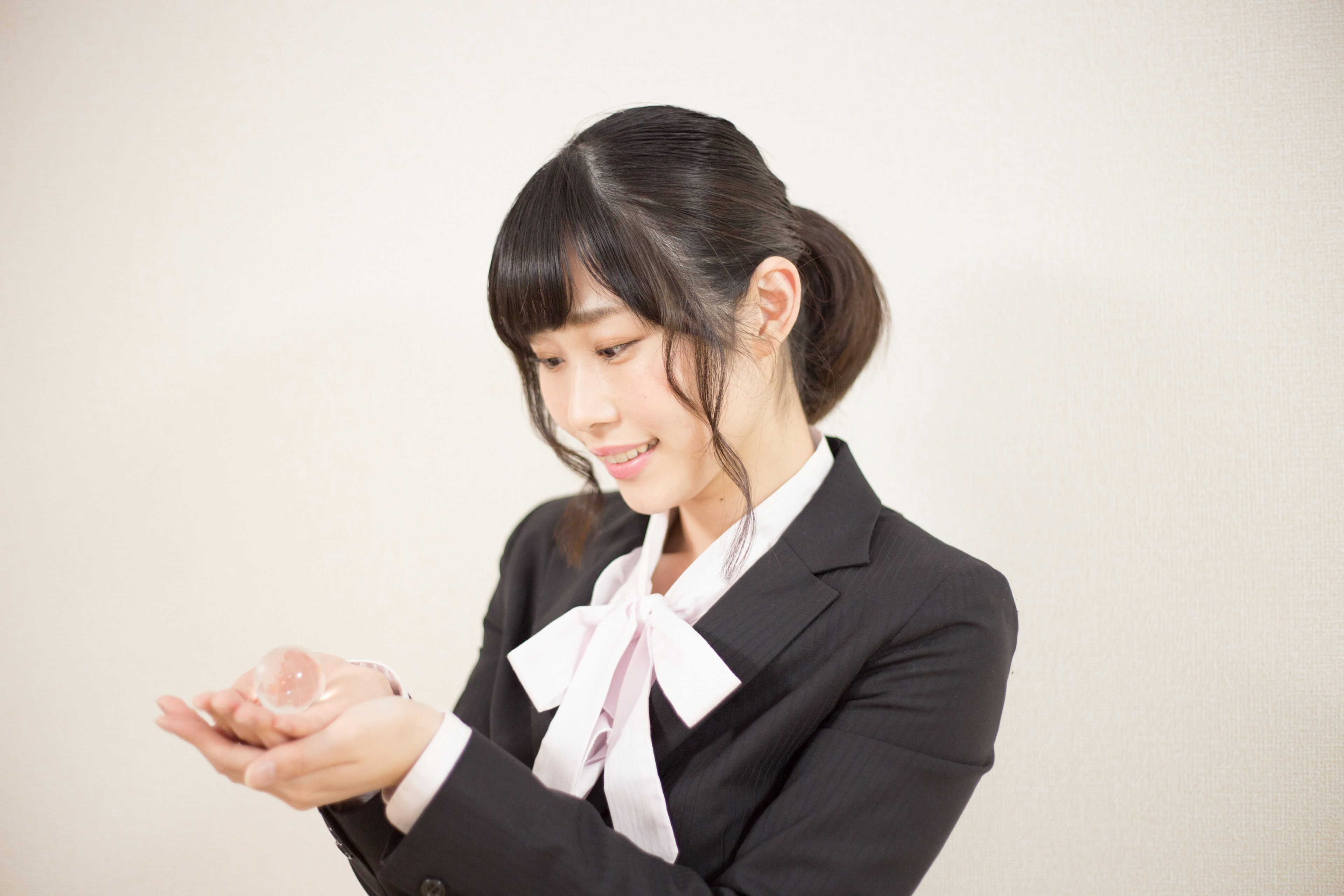 A woman in a suit smiling while holding her hands upward