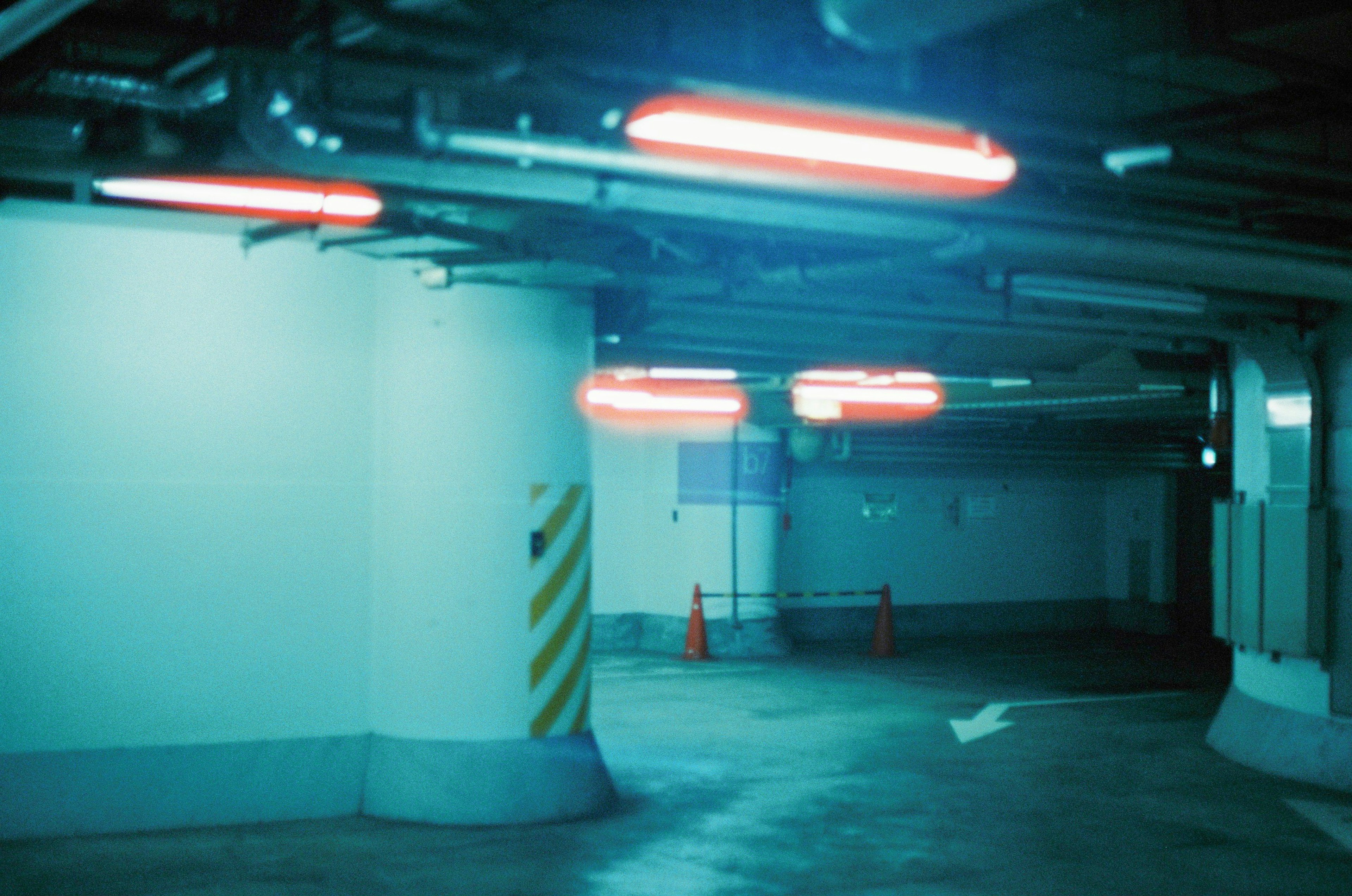 Intérieur d'un garage de stationnement avec des tons bleus et des lumières rouges allumées