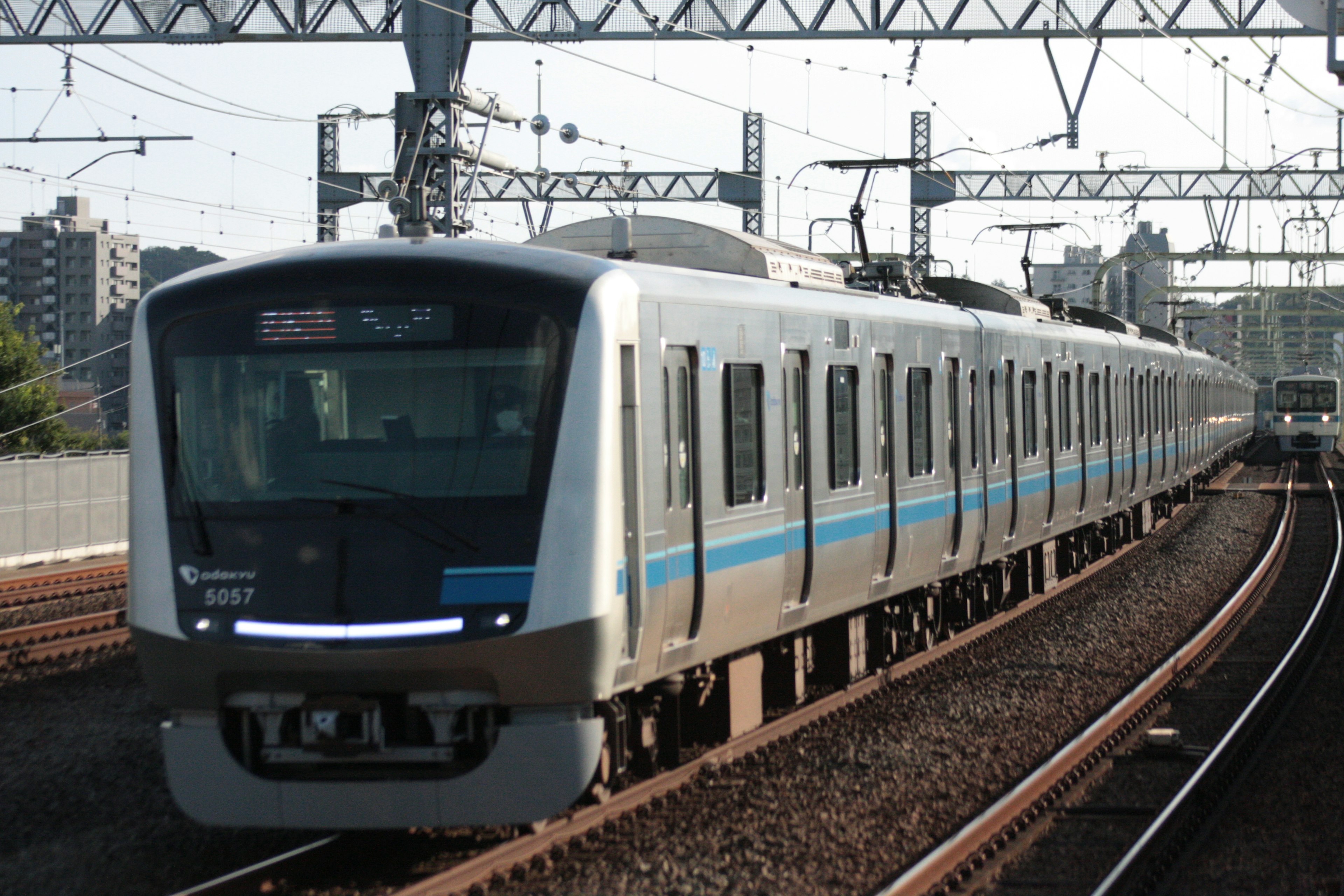 Tren moderno con franjas azules circulando por las vías