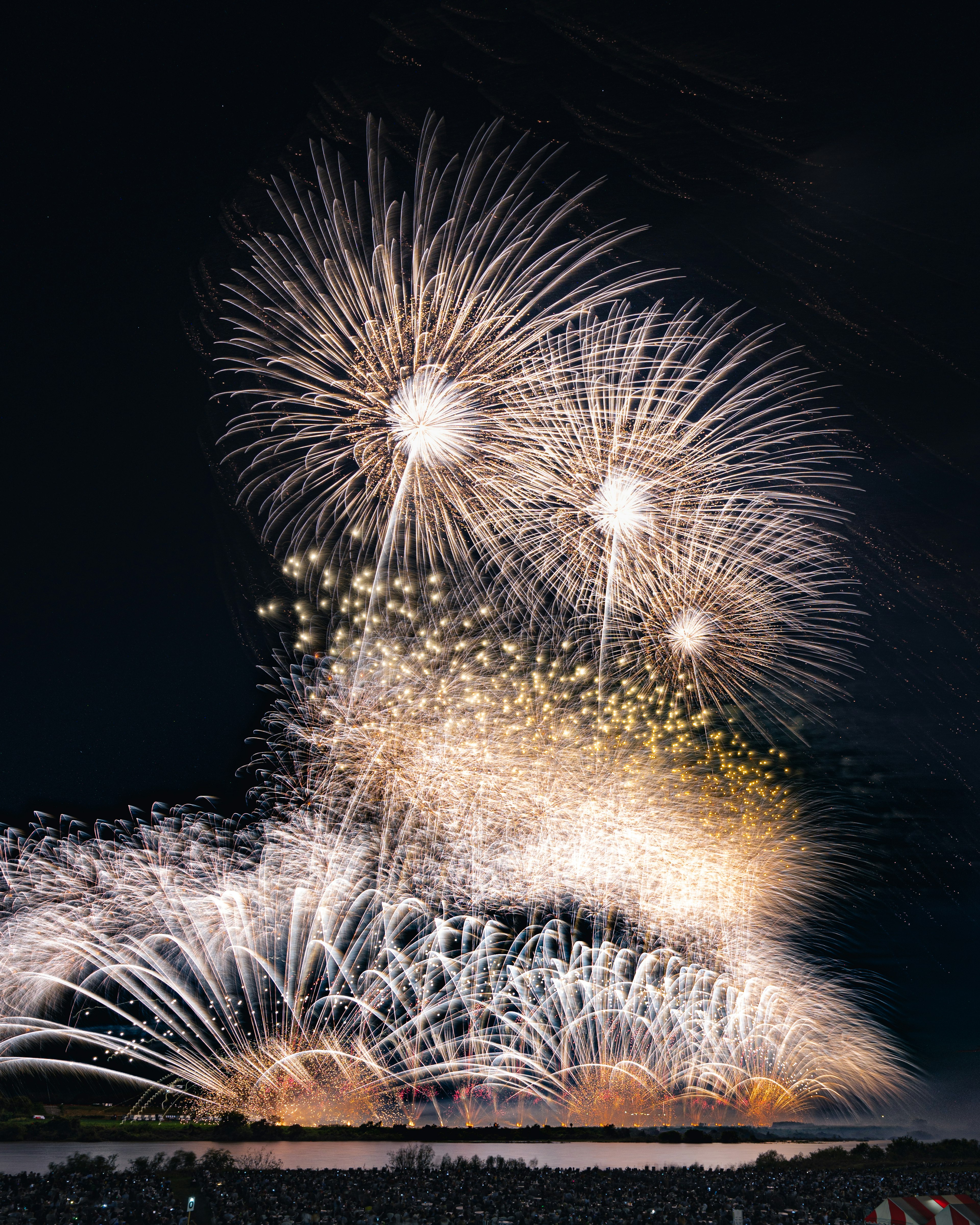 A spectacular display of large fireworks bursting in the night sky