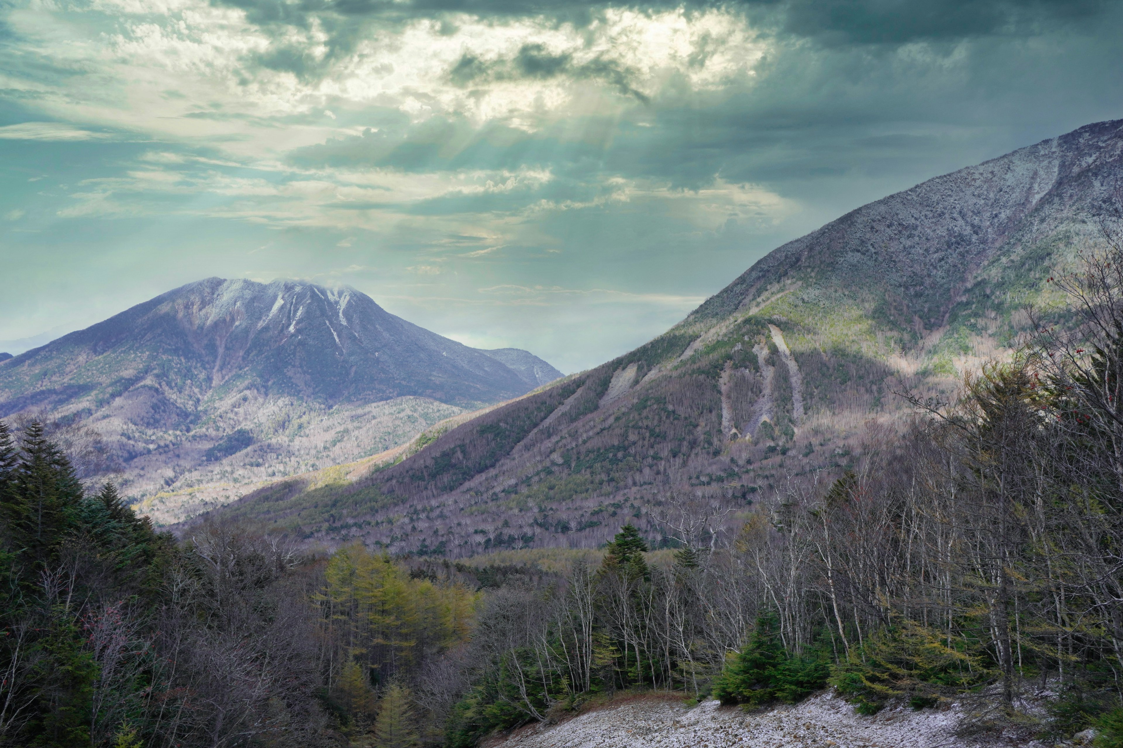 緑豊かな山々と雲の多い空の風景