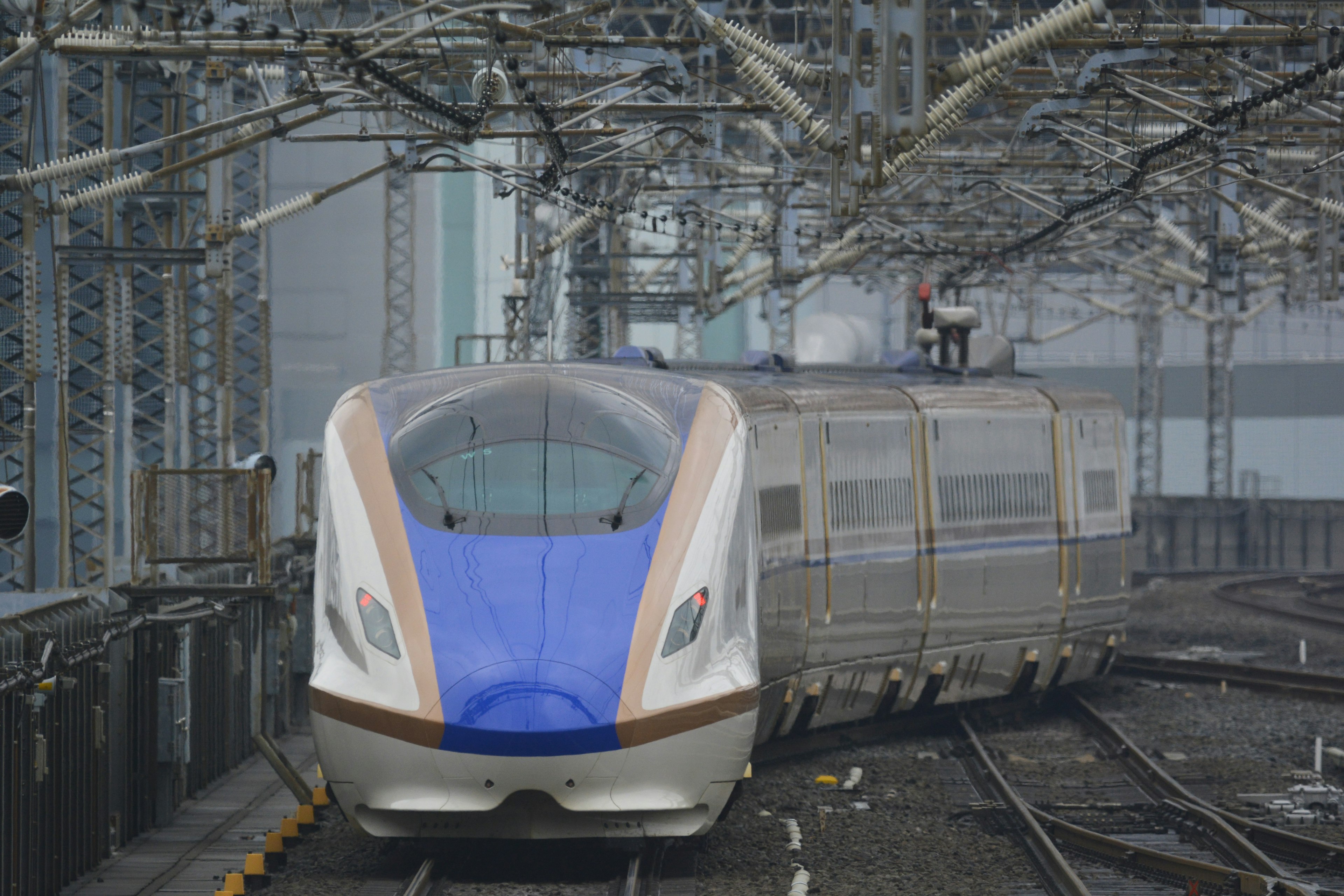 Ein blauer Shinkansen-Zug, der auf den Gleisen steht