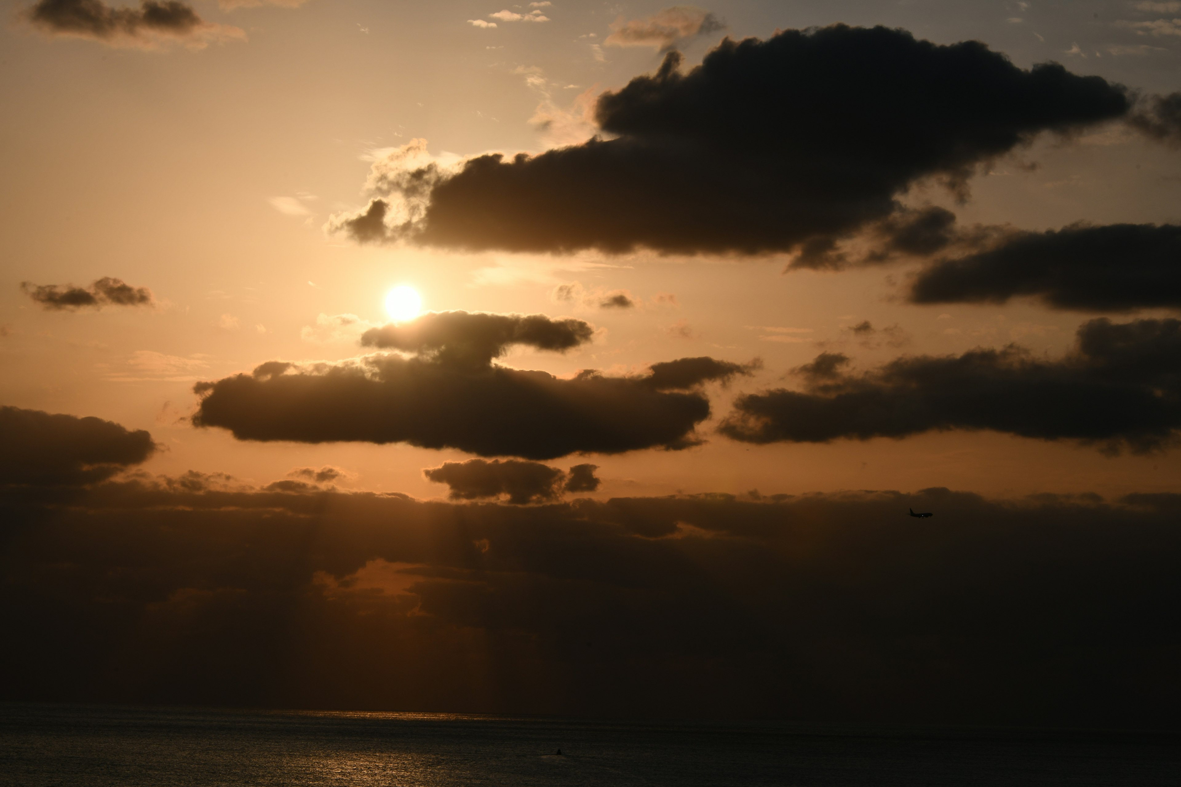 Hermoso paisaje con el sol poniente brillando a través de las nubes