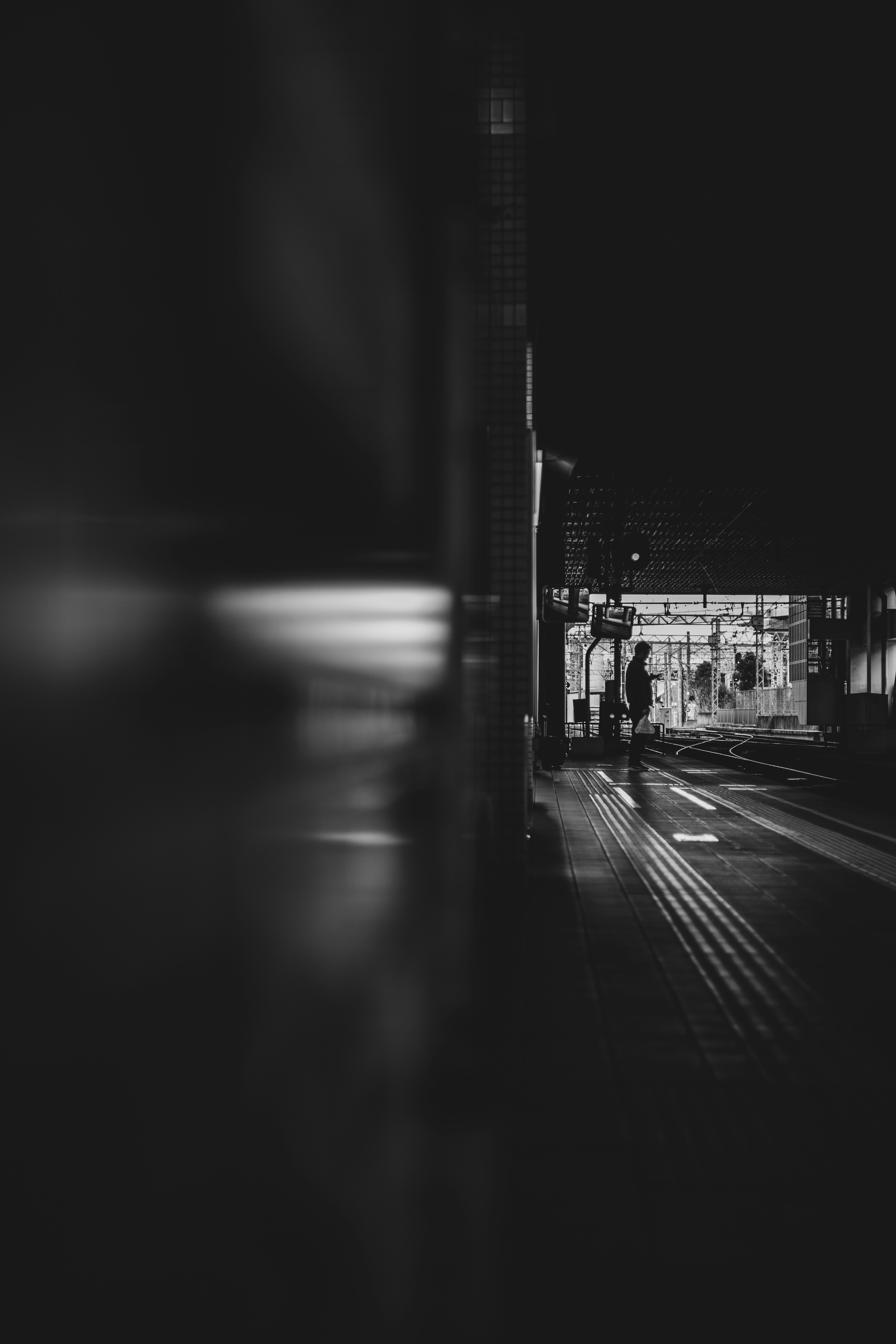 夜の駅で人が歩いているモノクロの写真