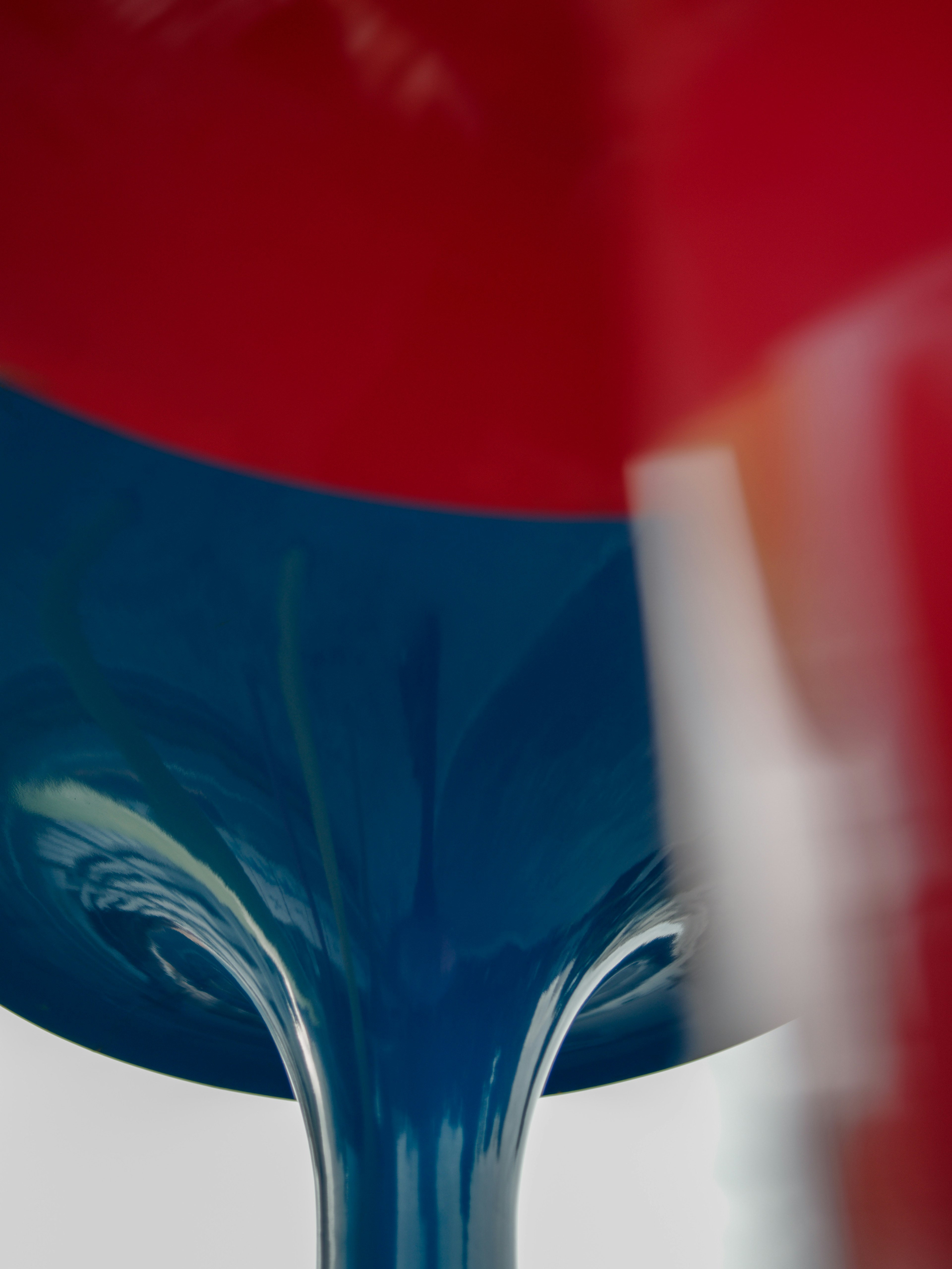 Gros plan sur un verre avec un liquide coloré rouge et bleu qui se verse