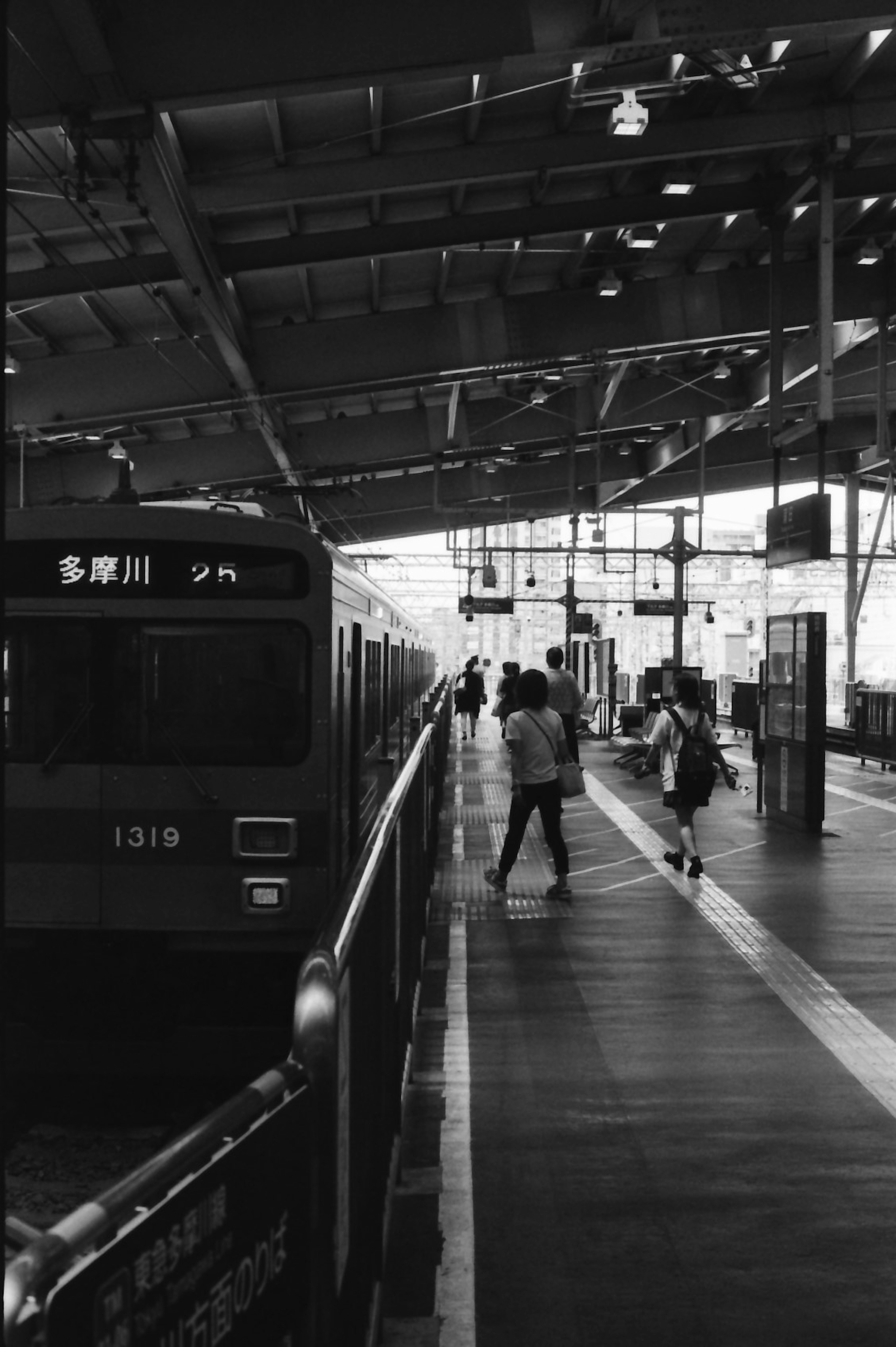 駅のプラットフォームに立つ人々と電車の風景