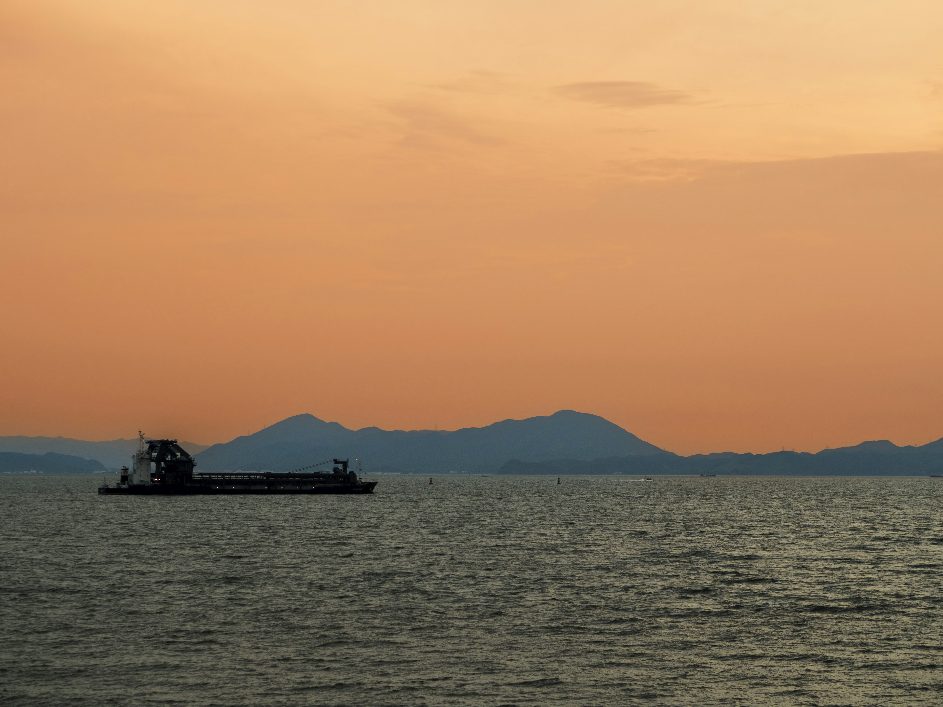 夕焼けの空を背景にした海上の船舶