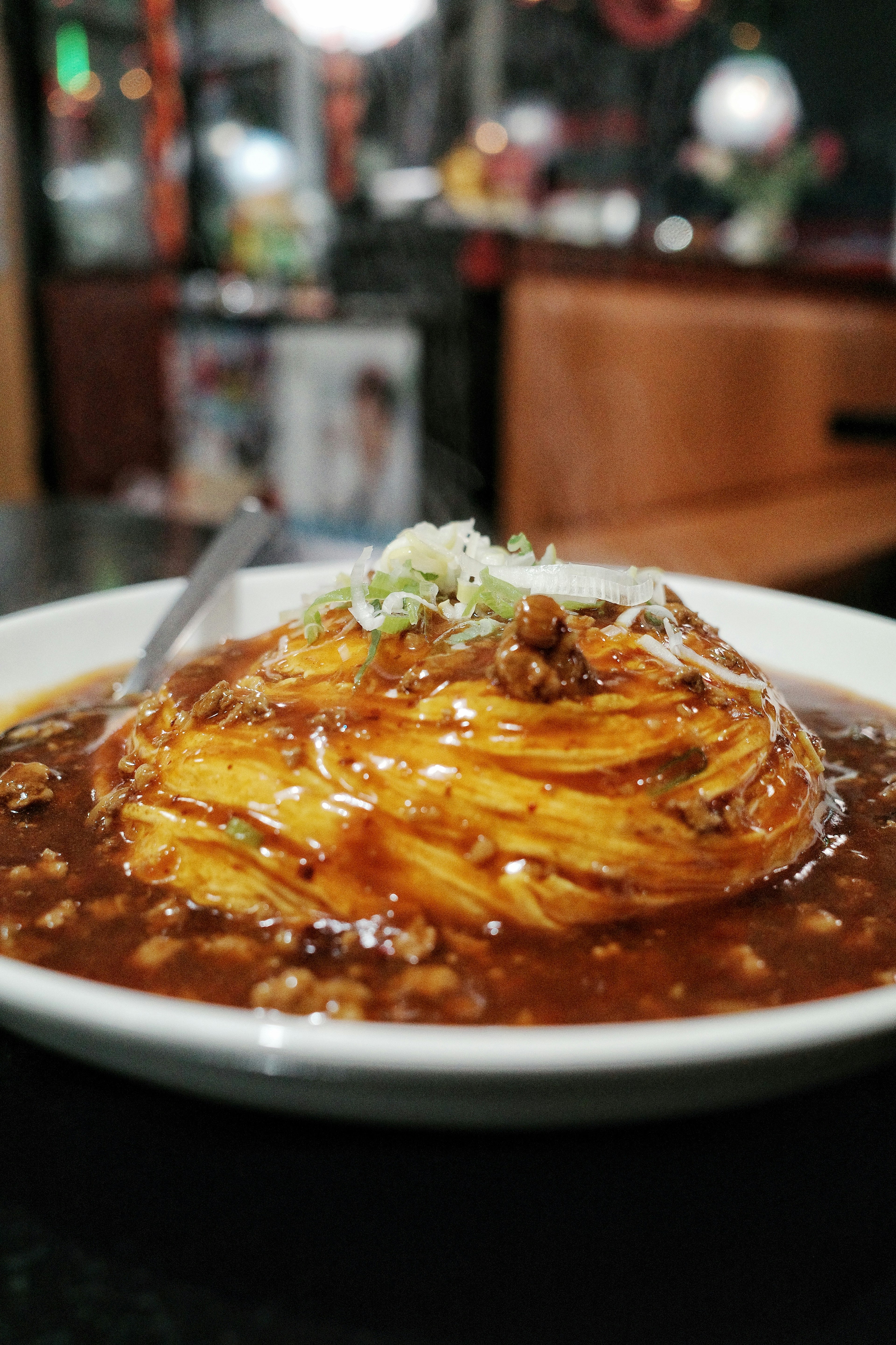 Hidangan yakisoba yang disajikan dengan indah, dilapisi saus dan bawang hijau