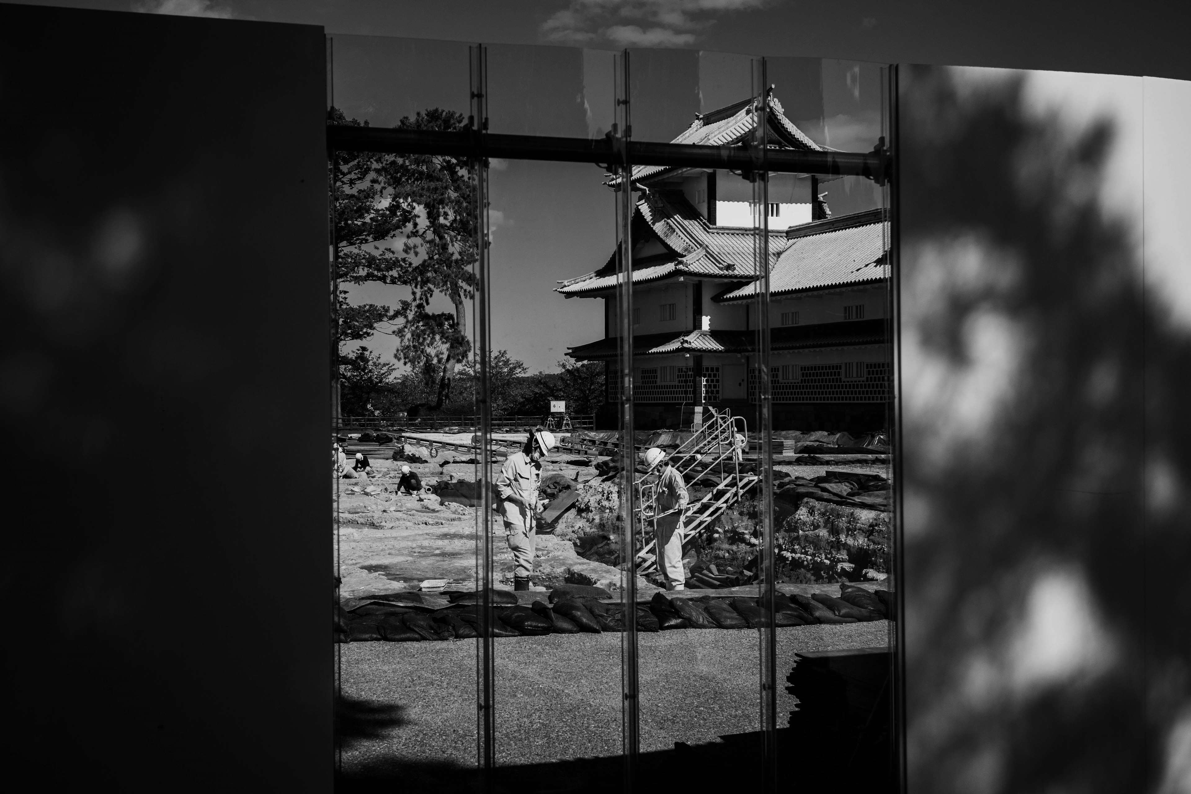 Schwarz-Weiß-Bild, das einen japanischen Garten mit historischer Architektur reflektiert