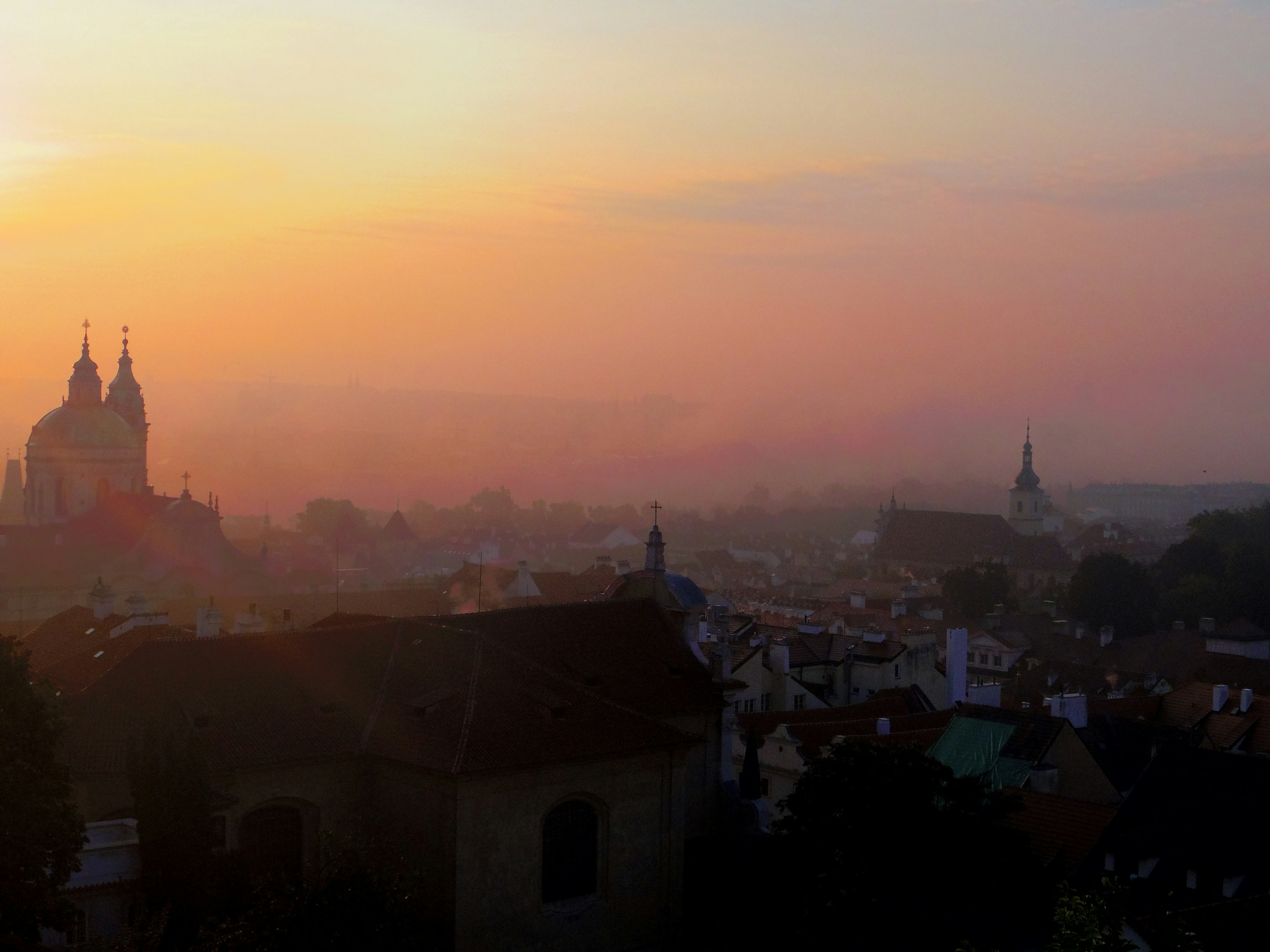 Hermosa vista de la ciudad al atardecer con siluetas de iglesias