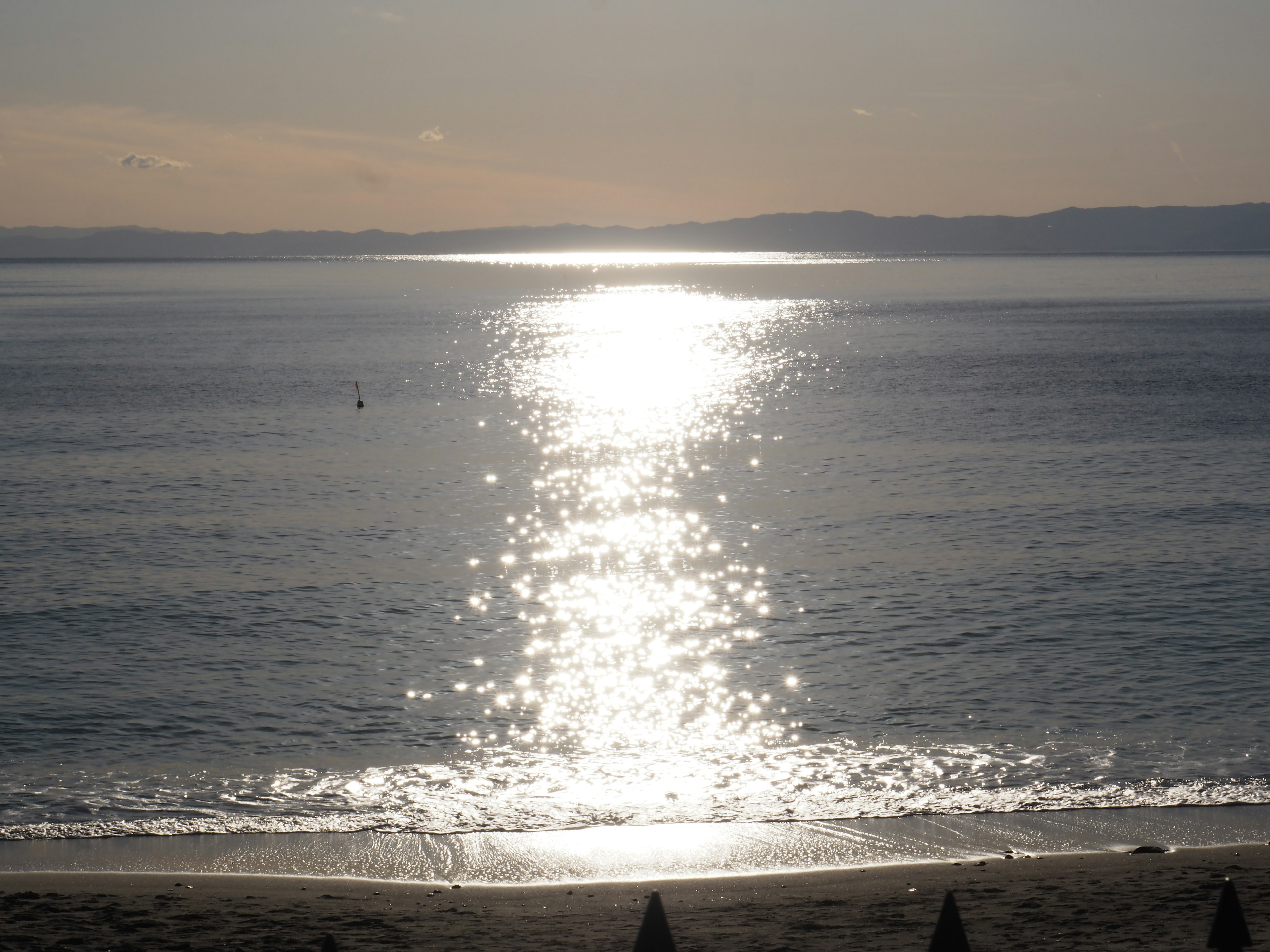 Paesaggio marino calmo con riflesso del sole sull'acqua