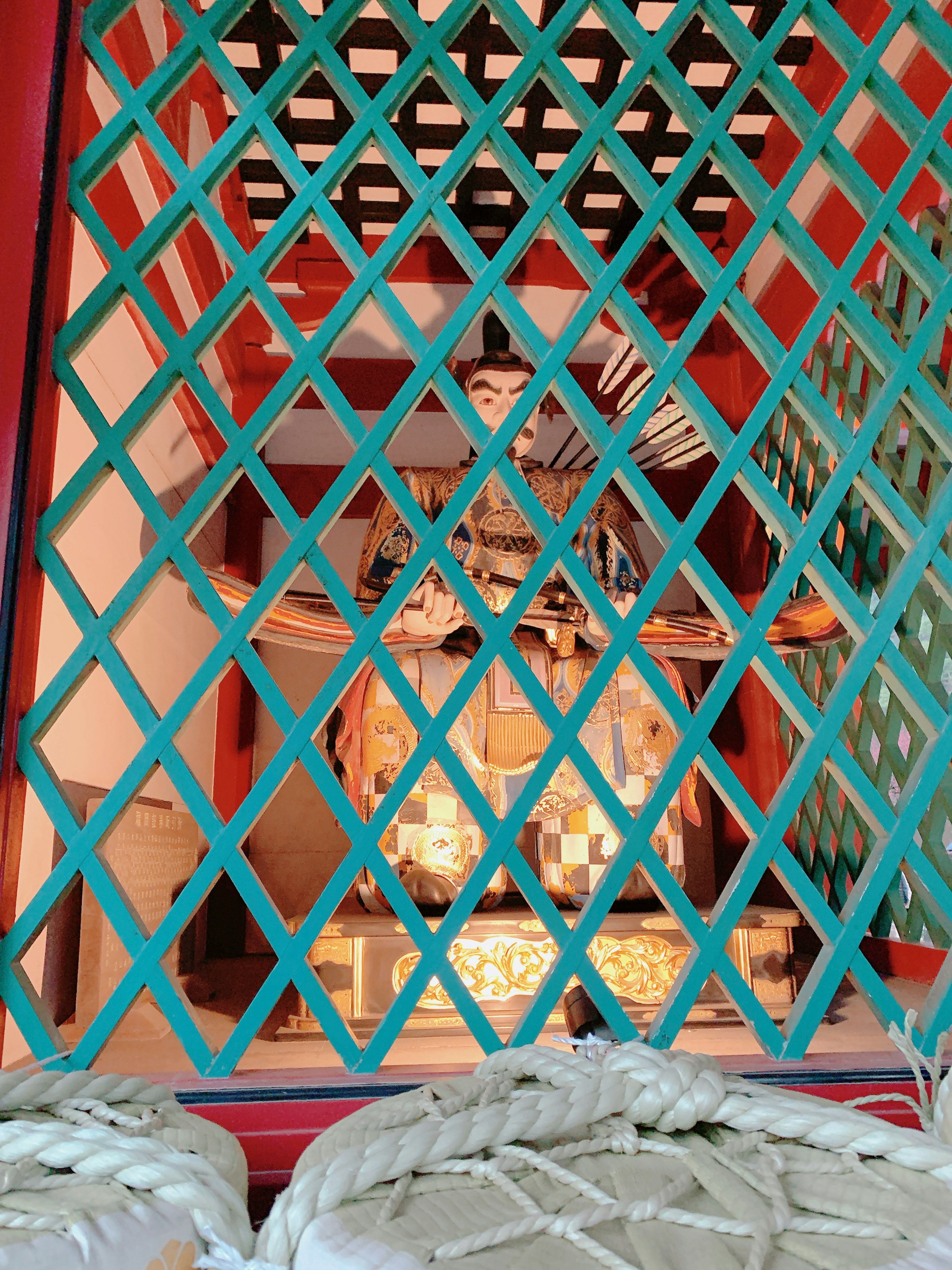 Vue d'un autel de sanctuaire à travers une fenêtre en treillis vert